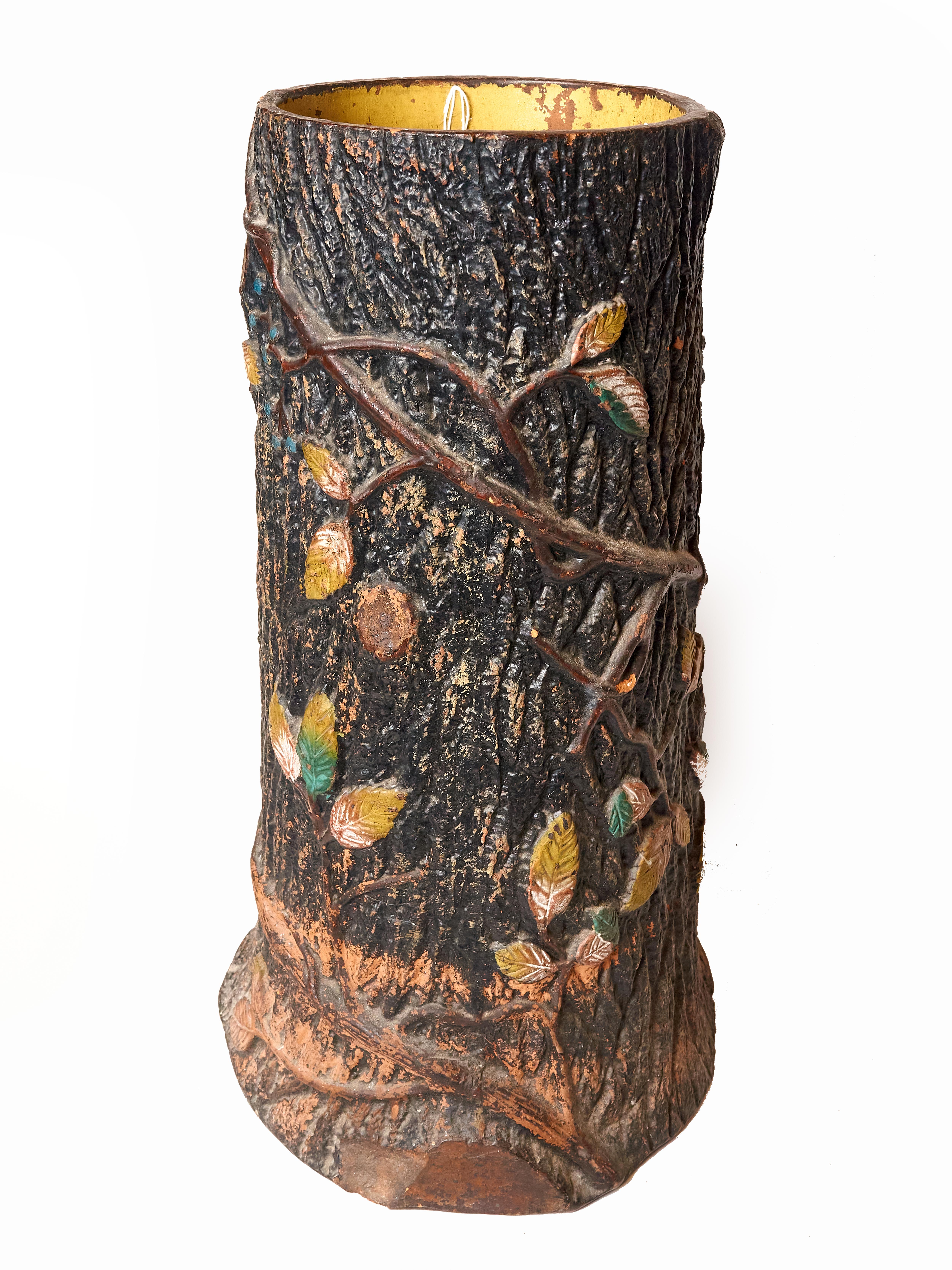 Unusual and rare red clay pottery umbrella stand circa 1930s believed to have been made in England. Fashioned to look like a tree stump with climbing vines and leaves. There are small scattered losses to the paint but no cracks or chips. The inside