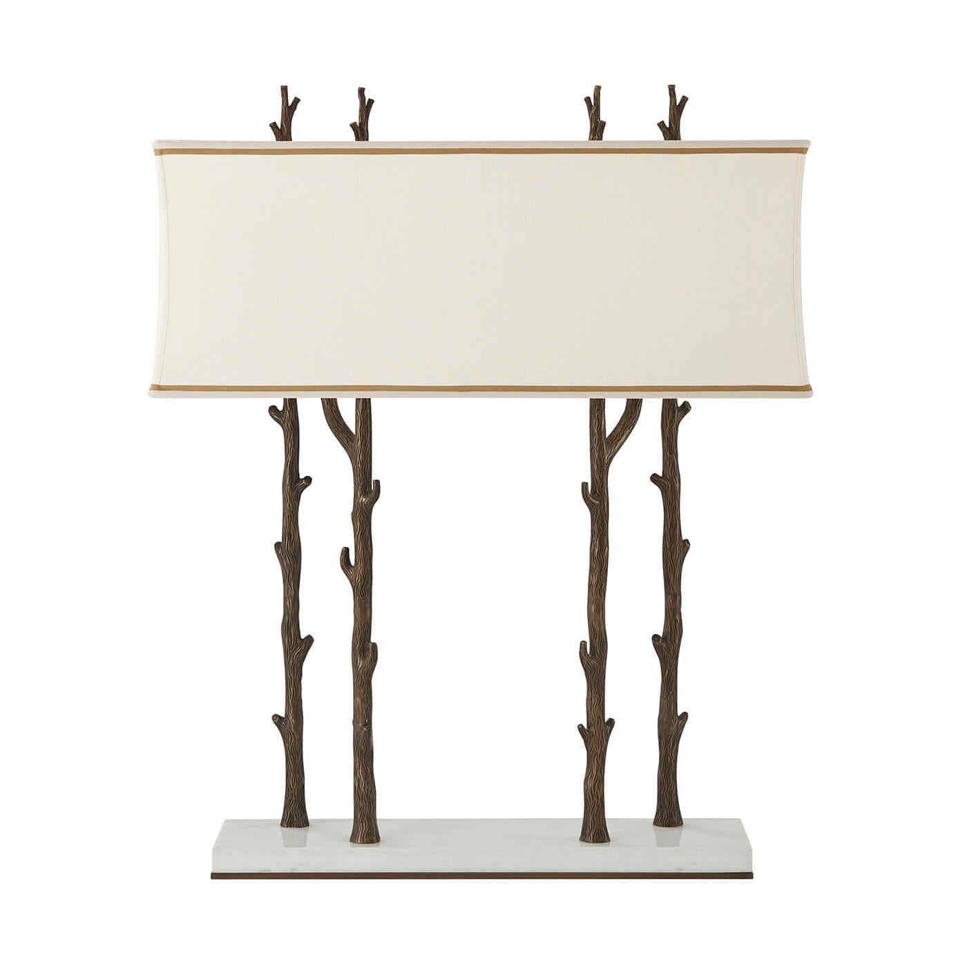 A faux bois brass table lamp, the fine white marble base with four faux bois tree trunks supporting the elongated rectangular shade enclosing all four trees, surmounted by branch finials.

Dimensions: 26