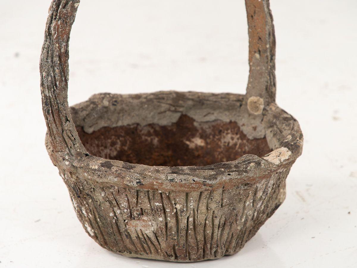 An early 20th century detailed faux bois cast stone planter in the shape of a basket with handle. The orname faux bois pattern on the basket and the handle are a reflection of the quality of the original production of this piece. This piece has