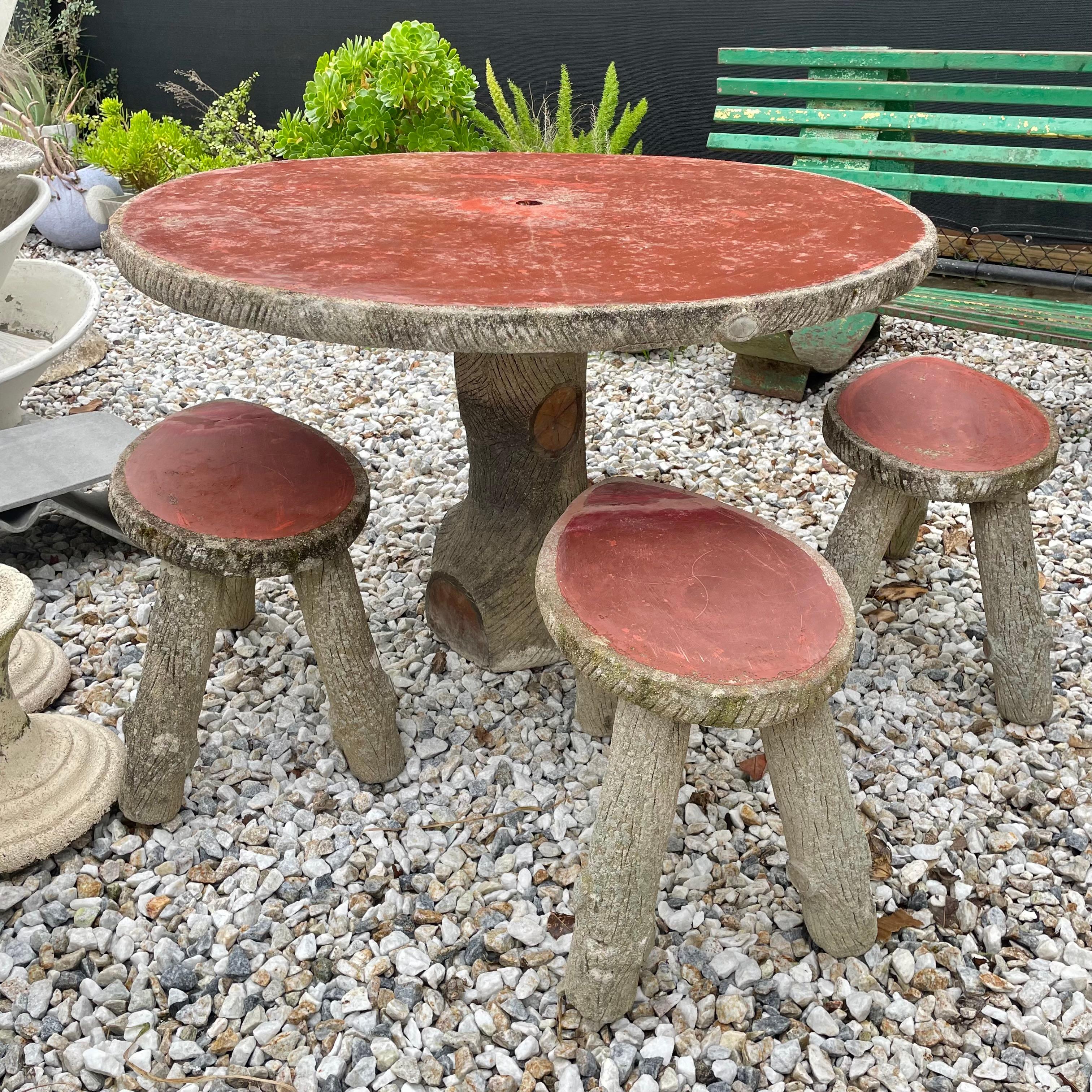 Substantielle table et tabourets en béton faux-bois de France, fabriqués dans les années 1970. Dessus des tabourets et de la table peints. Cet ensemble comprend 5 tabourets et une table. Les pieds et la base de la table ressemblent à des troncs