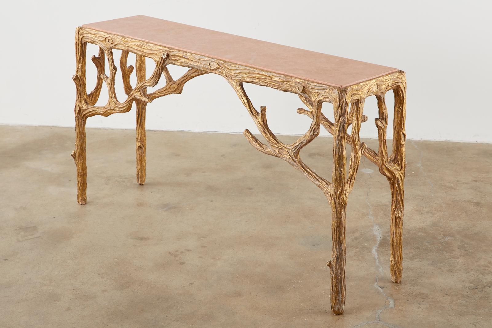 Dramatic faux-bois console or sofa table designed by Horatio Acuna. Features a gesso and gilt finish on the twig branch motif frame. Topped with a faux marble inset finished in a rosé color. Beautifully handcrafted with an aged patina. Signed and