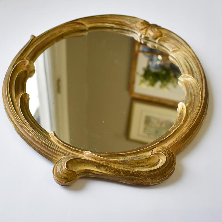 Faux bois oval wall mirror with details of wood vines sheaves of wheat and leaves. This piece is by the Syroco Wood Company from New York and estimated to be from the 1940s. 

This beautiful and rare find features lovely curled vines and leaves