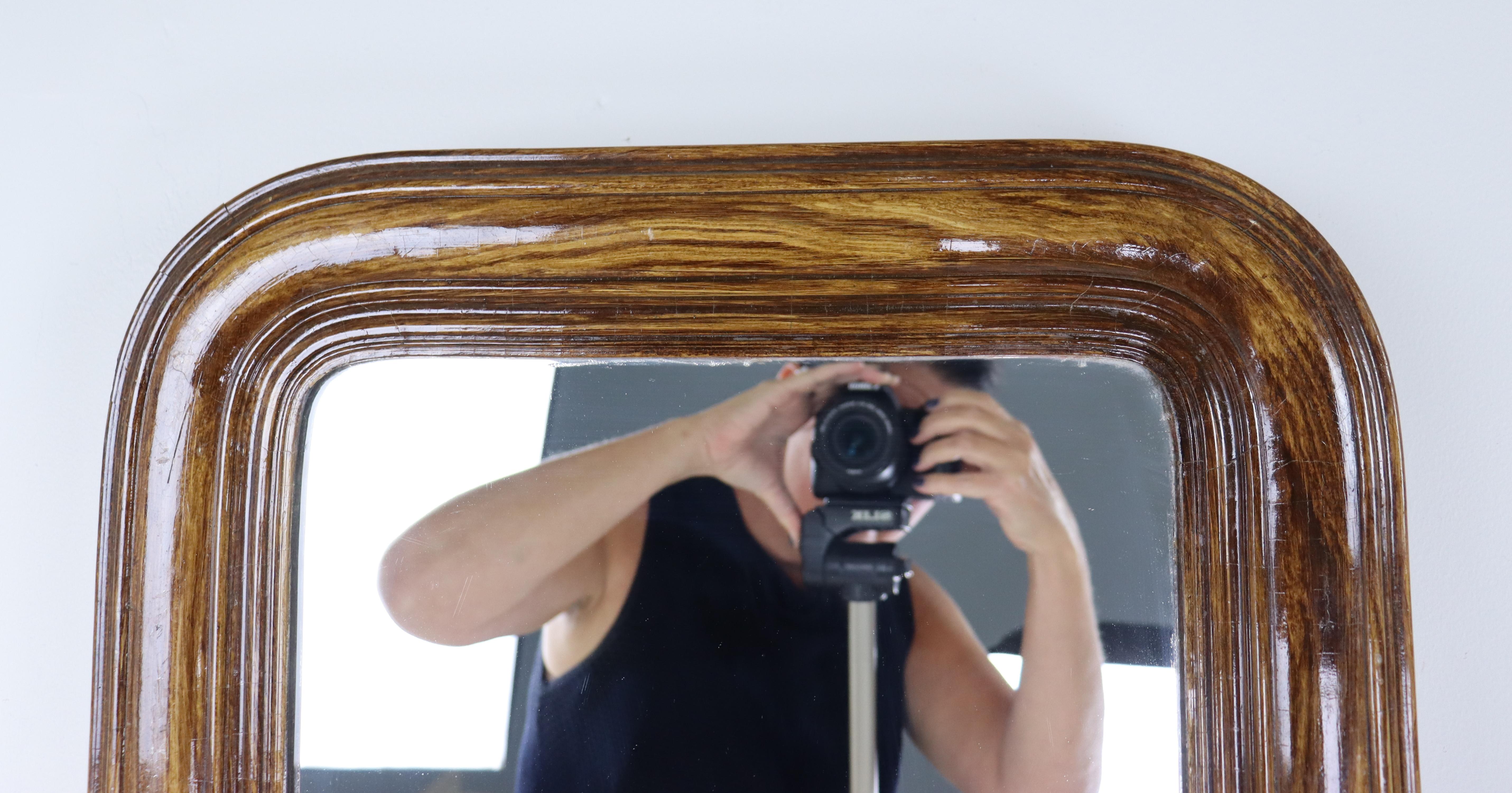 A medium sized Louis Phillip mirror, made traditionally of wood covered with gesso, and in this case, faux bois painted to resemble wood.  Very eye catching, though there are some minor chips and scrathes, shown in thumbnails.  Glass is in good