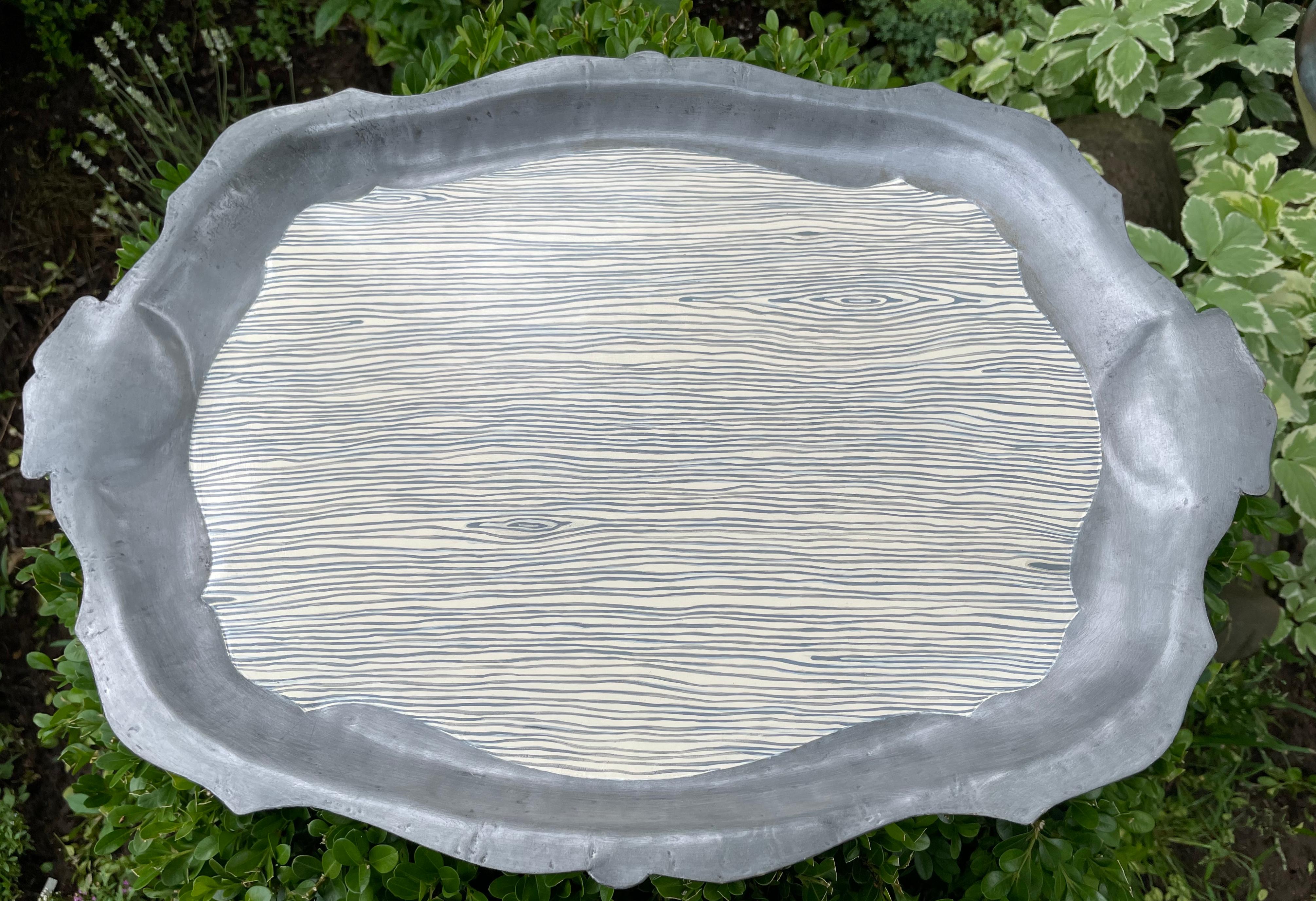 Vassoio in tole di finto bois. Vassoio a forma di tole unico nel suo genere, con manici e pannello centrale in design tôle peinte in faux bois color crema e grigio blu. Continentale, 20° secolo
Dimensioni: 19