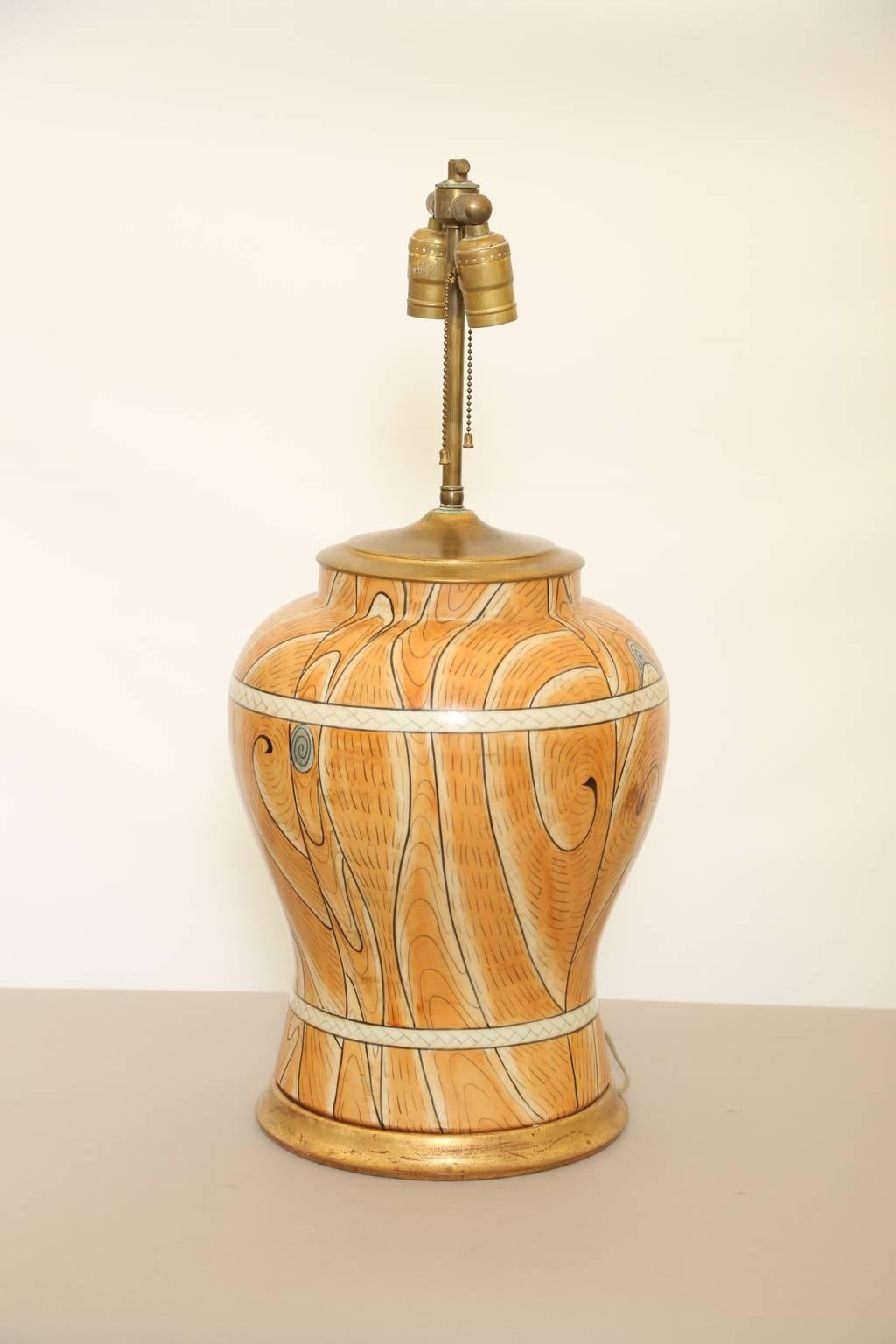 Unusual lamp, of glazed pottery, its baluster form hand-painted with trompe l'oeil wood grain planks and bands, to resemble a barrel, on round giltwood base. 

Stock ID: D1473.