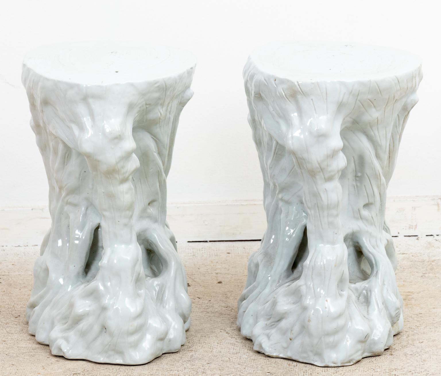 Circa mid-20th century pair of faux bois branch shaped white ceramic garden seats in the Palm Beach Regency style. Please note of wear consistent with age including factory flaws, flea bites, and scant paint loss.