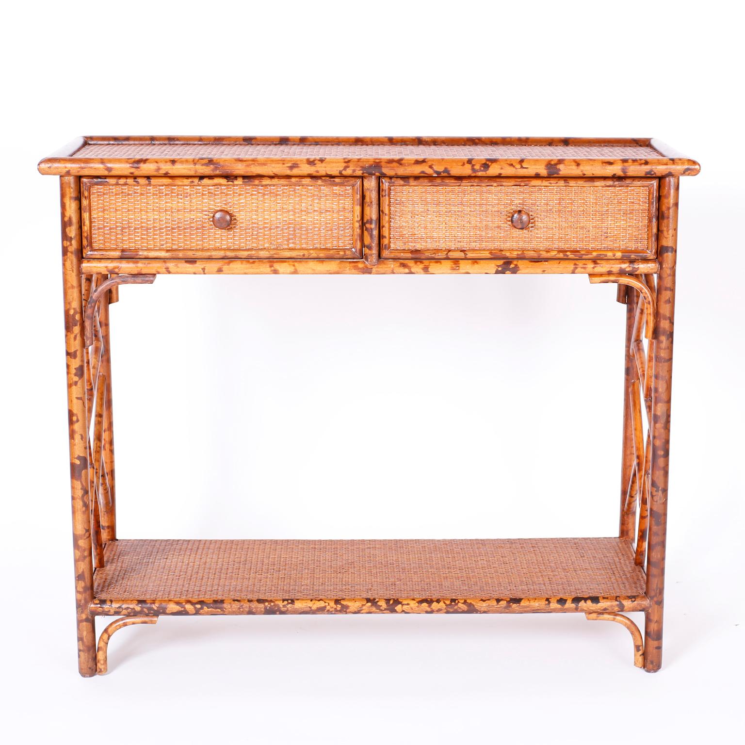 Mid century two drawer console table with a faux burnt bamboo frame, grasscloth panels, Chinese chippendale sides, and a desirable slim profile.