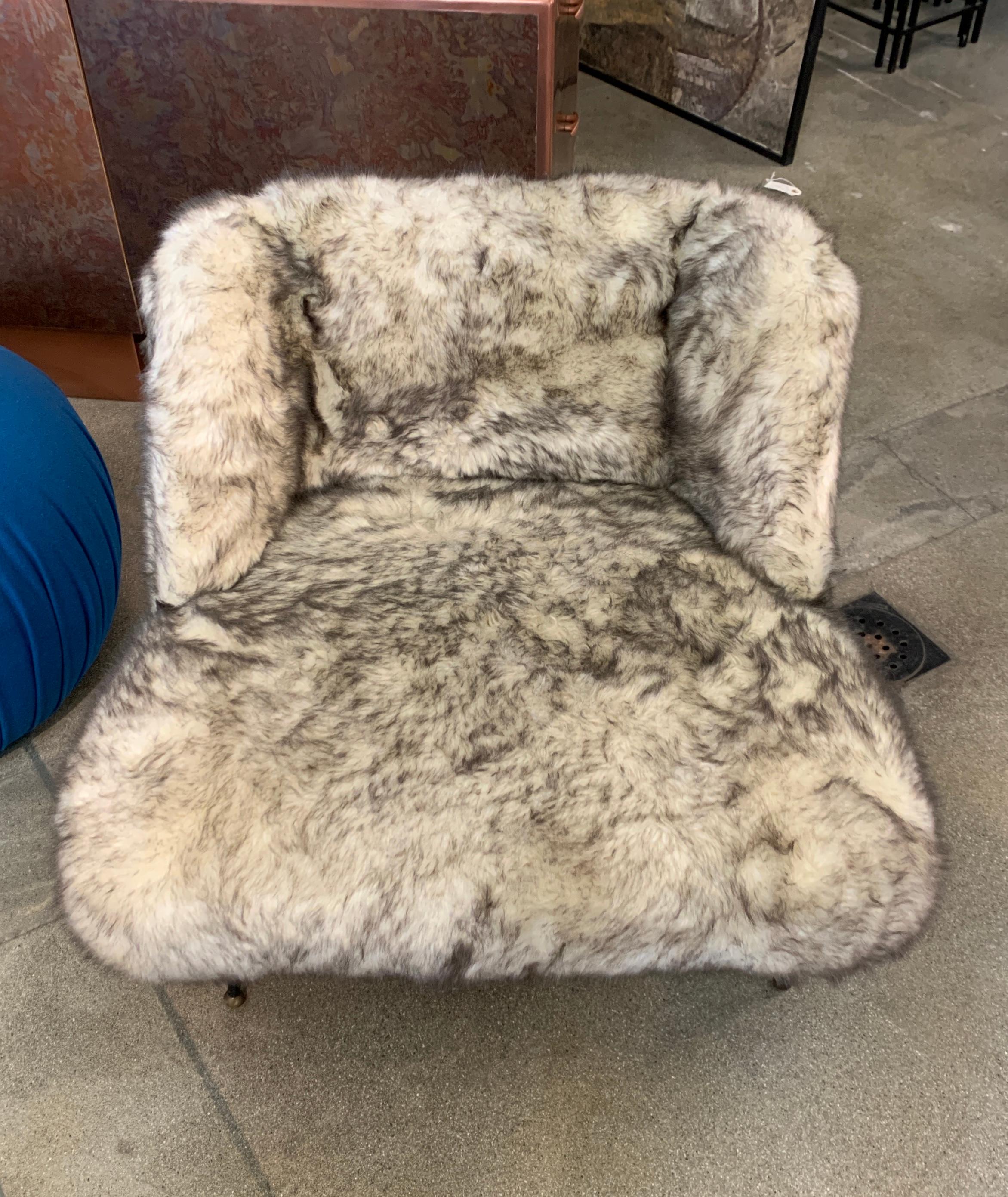 An iron base Faux Fur upholstered chair. It is likely French or European with a hand welded base. Reminiscent of designs by Mathiue mategot and Jean royere. Some of the screw heads are flat and appear older. The feet are brass and round. The chair