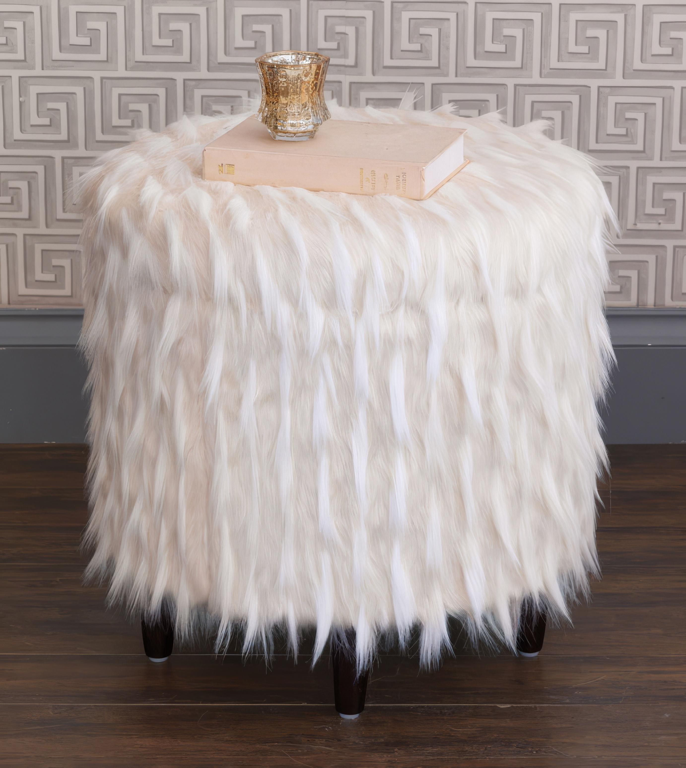 Fabriqué aux États-Unis par des maîtres tapissiers, cet ottoman à hauteur de lavabo est épais et rembourré de fausse fourrure somptueuse, offrant une expérience d'assise indulgente. Le couvercle amovible, fini avec un bord de couteau, dissimule un