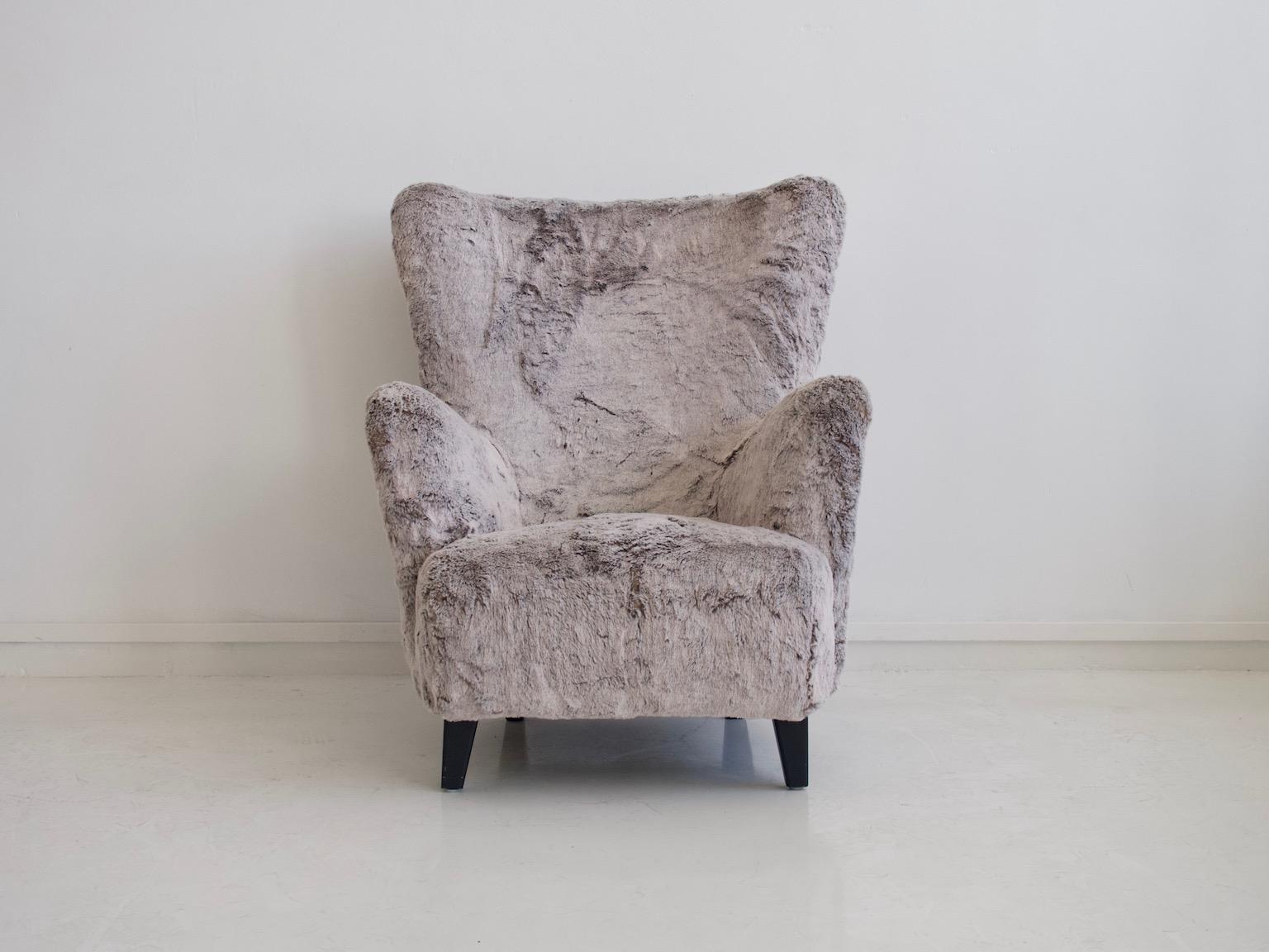 Armchair from the 1950s. Reupholstered with grey faux fur fabric. Legs made of stained wood. Very comfortable seat.