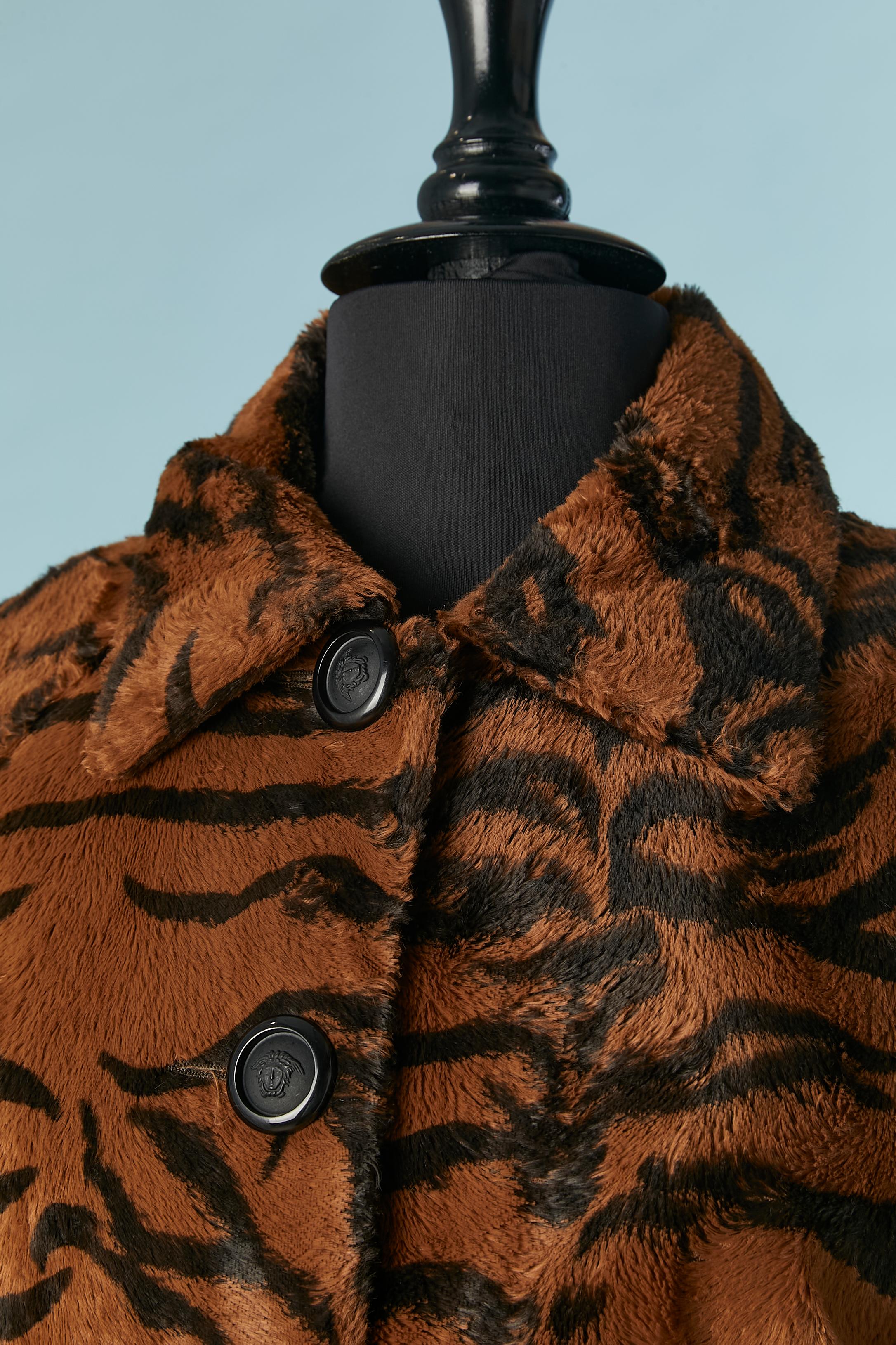 Faux furs skirt-suit with brown and black tiger pattern. Main fabric composition: 62% cotton, 38% rayon. Lining: 52% acetate, 48% polyester. 
Padding 100% polyester ( only inside the jacket) 
Authenticity hologram inside the jacket and skirt. 
SIZE