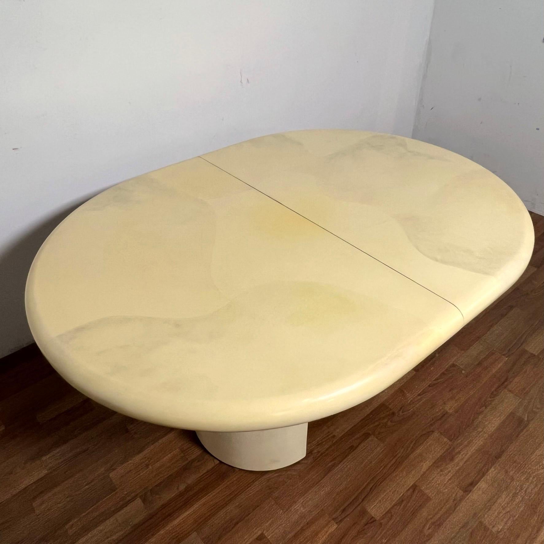 Table de salle à manger de forme ovale en CIRCA, finition laquée en fausse peau de chèvre, vers les années 1980. Comprend deux feuilles.  Mesure 60