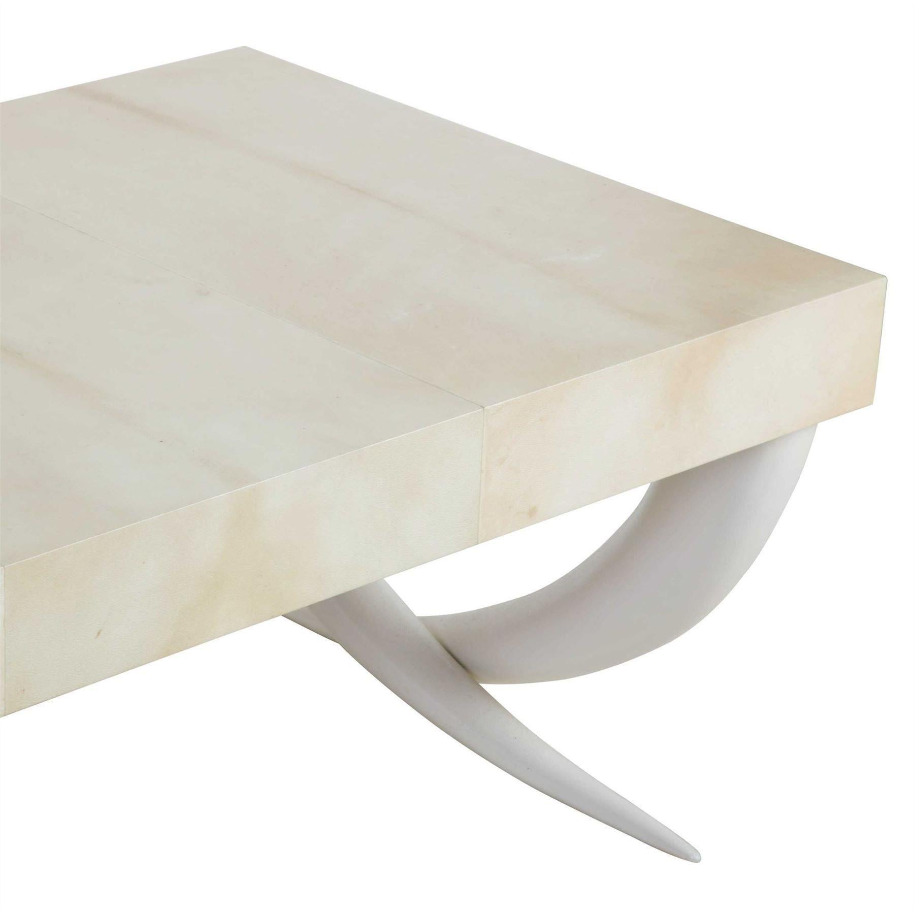 Une table basse avec des supports en fausse défense et un plateau plus récent recouvert de panneaux de parchemin.