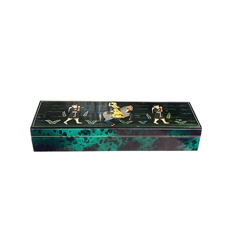 A beautiful unique Indian motif box with a lid. This piece would be fantastic for storing cigars, tv remotes, or miscellaneous items on a dresser or coffee table. The top of the box affixed on one side and is decorated with a hand-painted scene of a