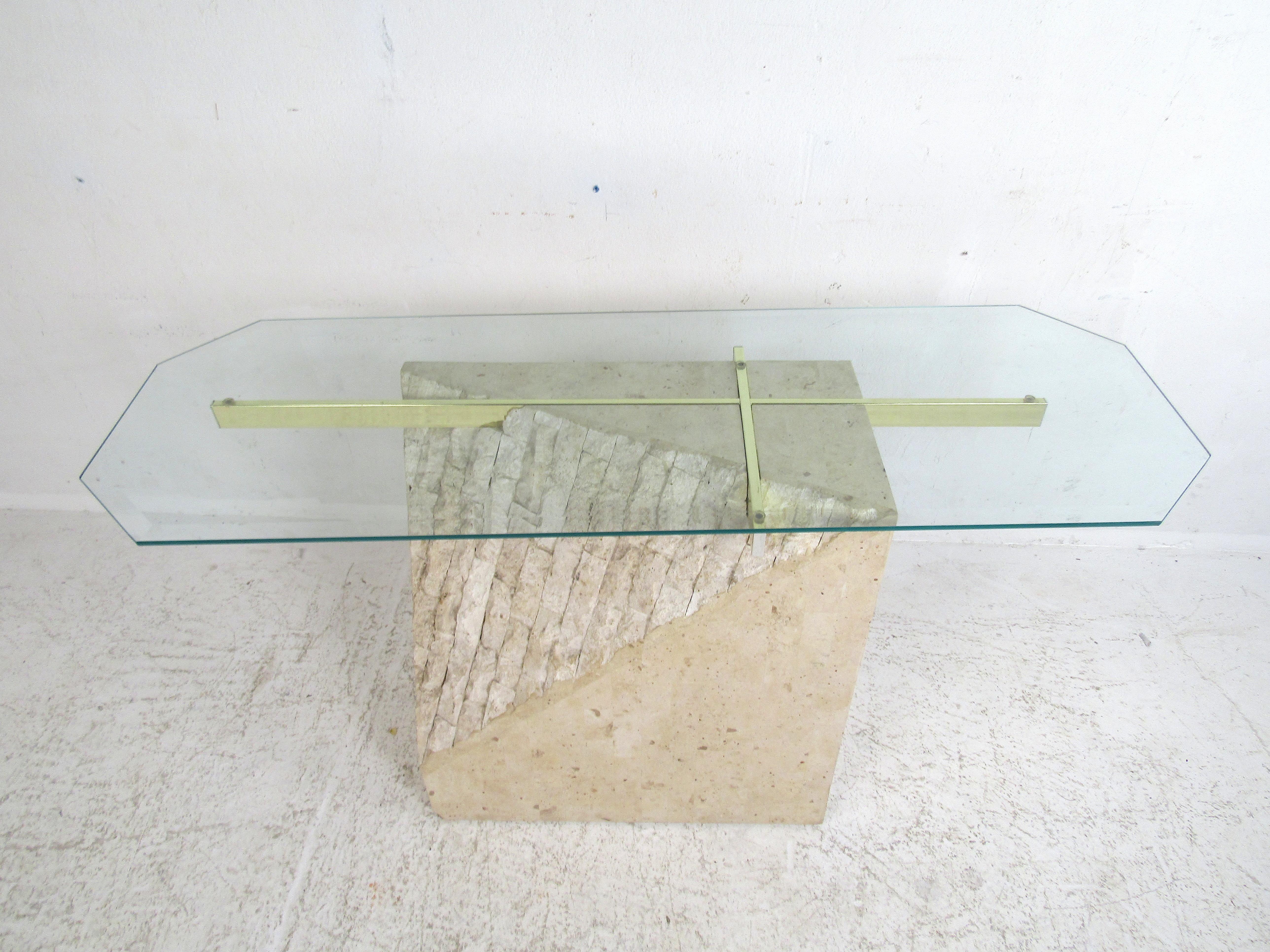 Stylish faux-marble console table in the style of Artedi. Sturdy base with a textured angular accent. Brass cross-section on the base supports a sizable glass tabletop. Perfectly suited for use as a hall or sofa table. Please confirm item location