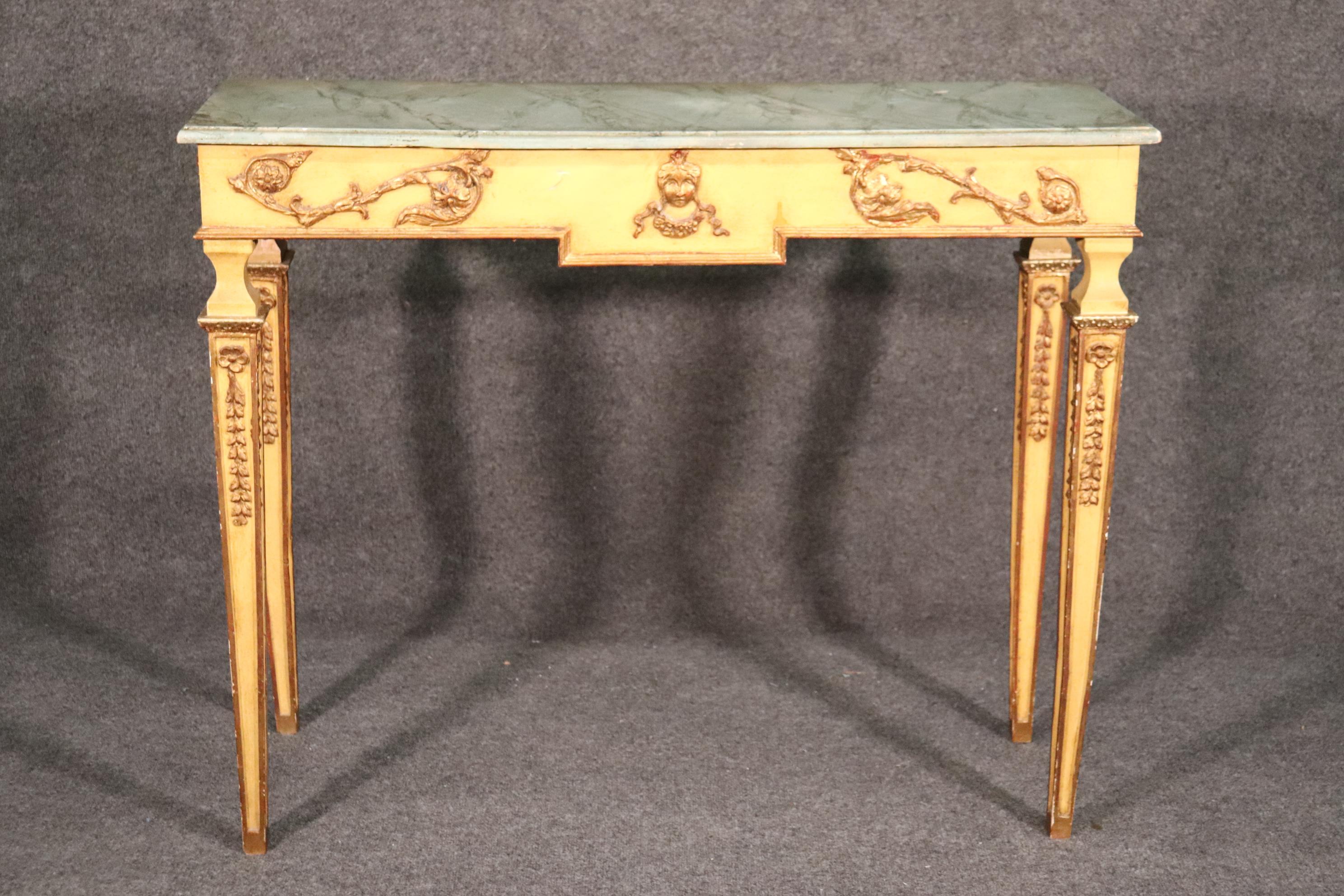 This table has a faux marble paint decorated top with gorgeous gold leaf and a creme painted frame. The faux marble is in good condition and very well done. The table dates to the 1940s era and measures 44 wide x 15 deep x 35 tall.