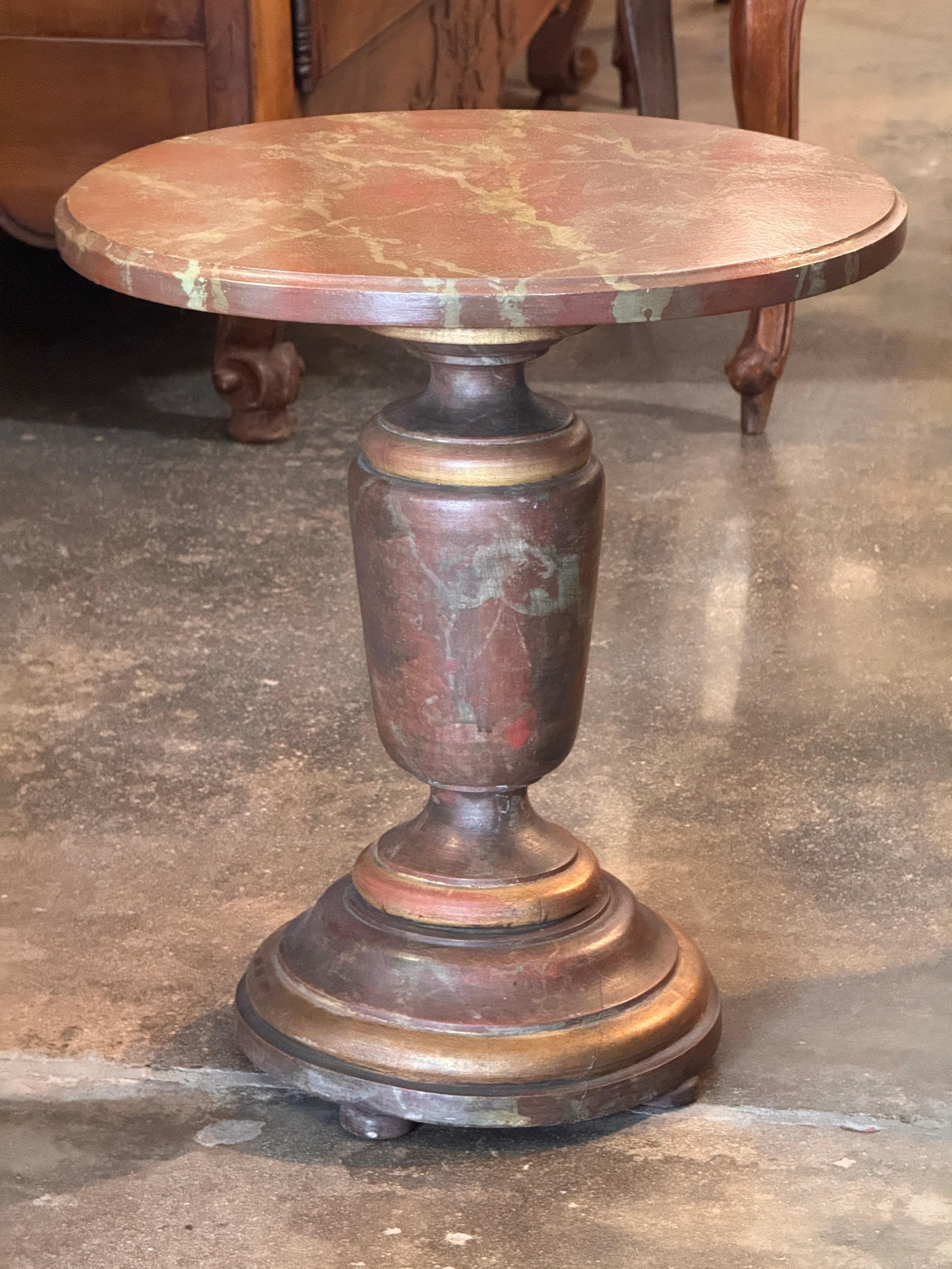 Round side table with a faux-marble painted top over a turned pedestal base. The painted surface shows age-use and scattered wear, and the base retains its original layered molding profile and small bun feet.