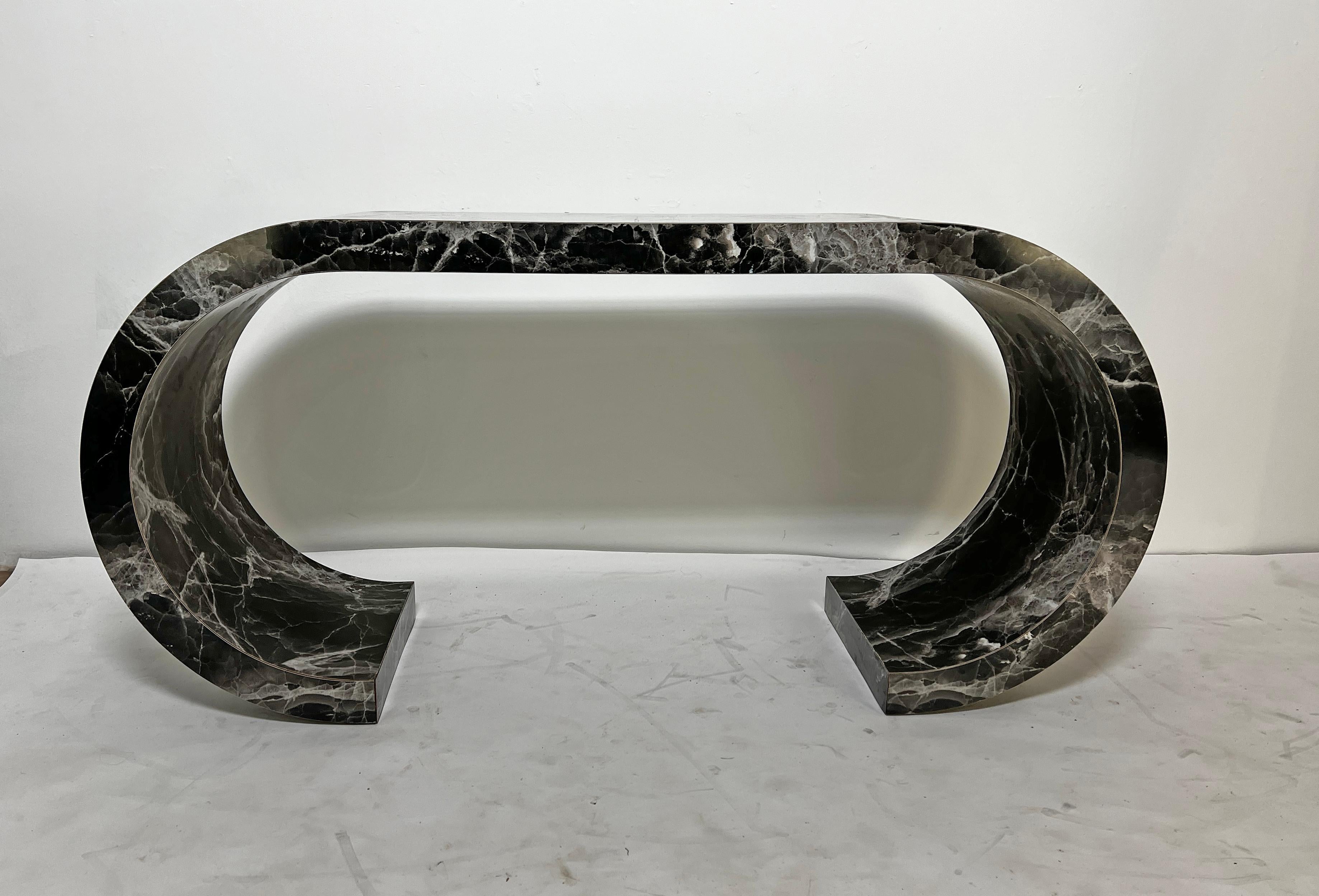 A scroll form console table in high pressure laminate with a faux marbled finish, circa 1970s.