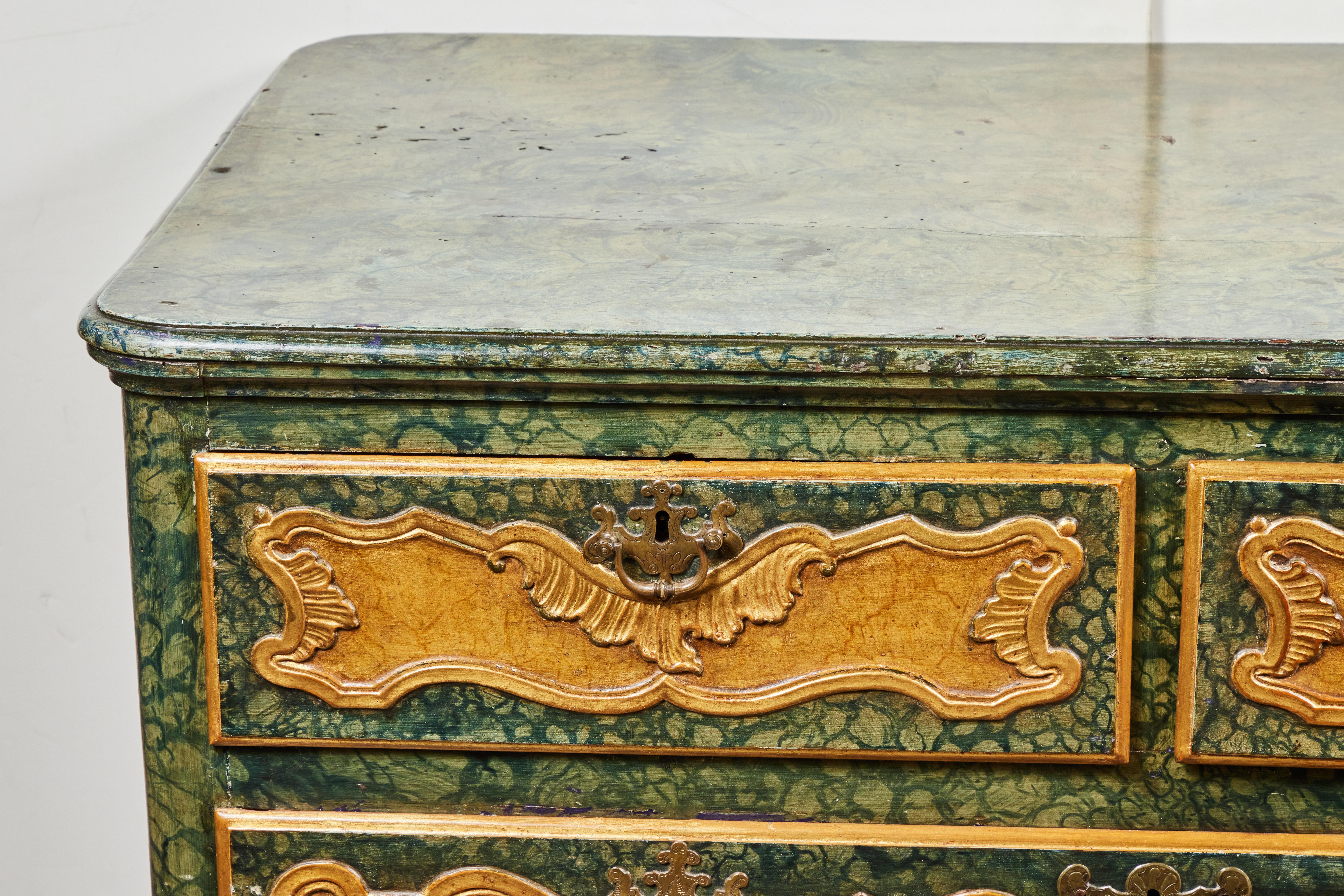 Magnifique commode vénitienne des années 1800, sculptée, peinte et dorée à la feuille, avec trois tiroirs à panneaux sinueux. Le tout en faux verde et marbrure de Sienne et agrémenté de gesso et de dorure à l'or 22k. Le tout surmonté d'un tablier