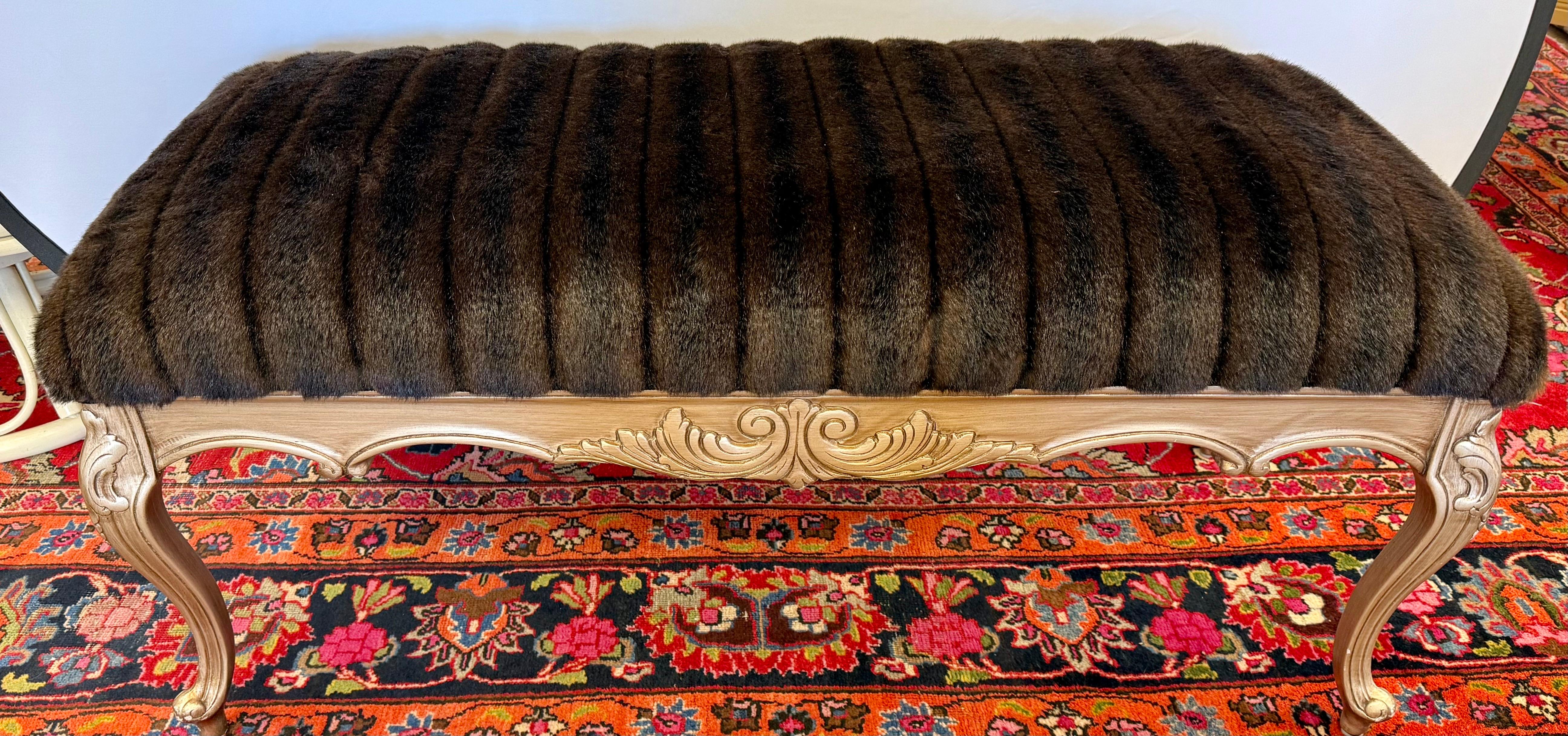 Banc élégant qui présente un revêtement en fausse fourrure de vison pour une assise douce et confortable et un aspect luxueux.  Un accent parfait pour votre salon, votre chambre à coucher, votre dressing ou votre salle de bain !