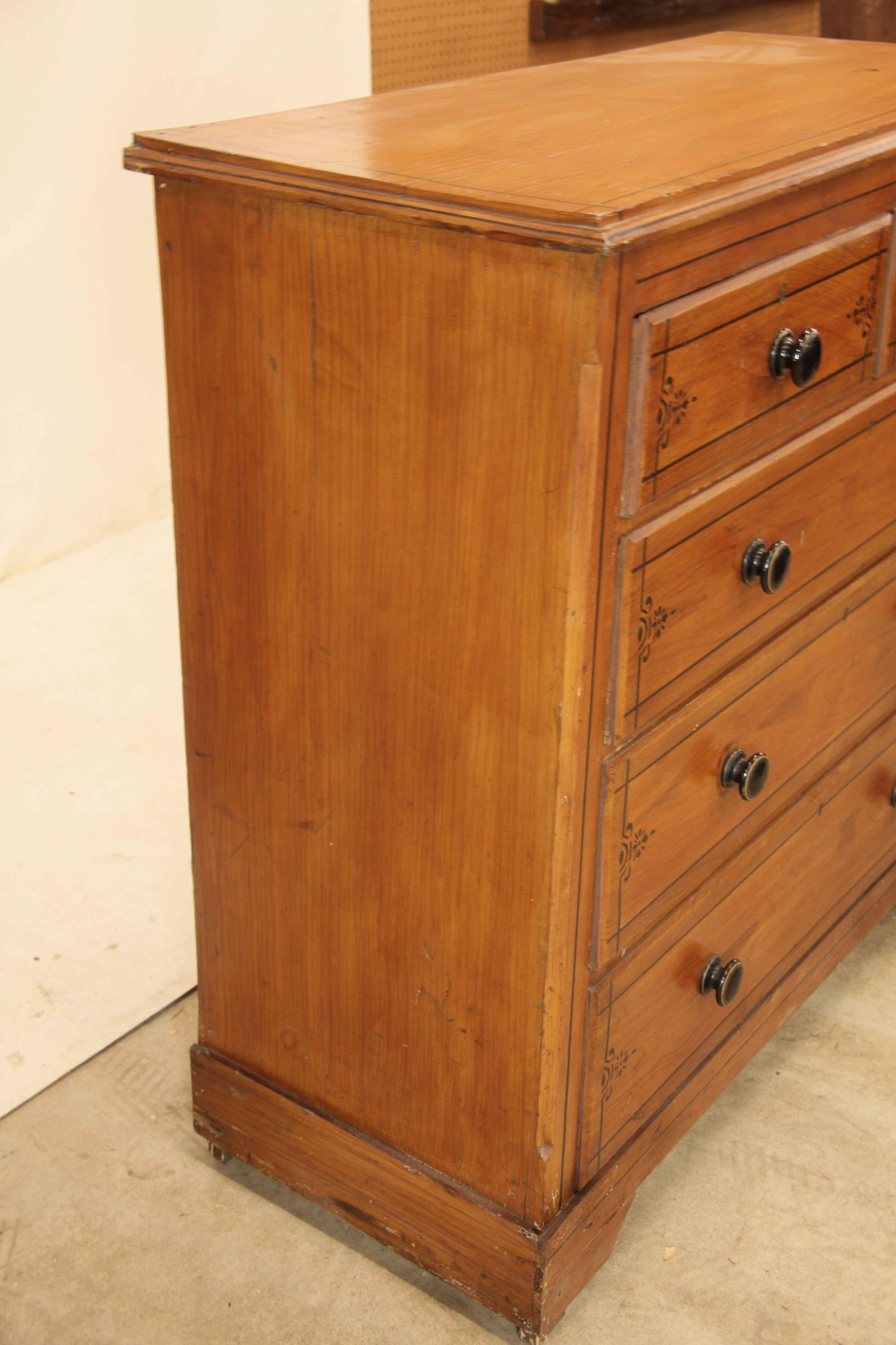 Cassapanca inglese dipinta a finto colore,  con vernice all over che simula le venature del legno,  Le linee nere sul piano e sui cassetti simulano l'intarsio dell'ebano.  I pomelli sono in ceramica nera smaltata e sembrano essere originali.  