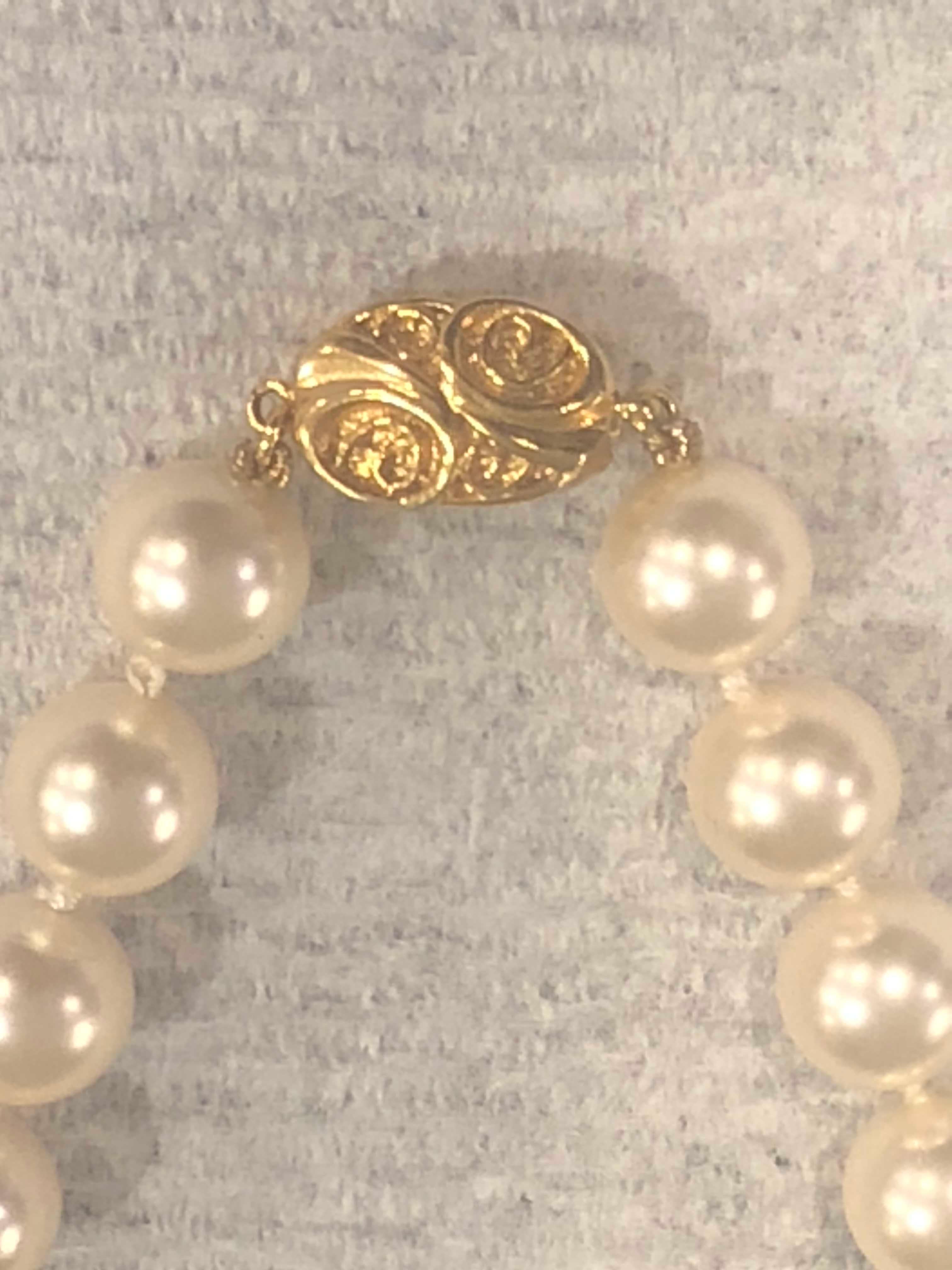 Kunstperlen-Halsband mit plattierter Medaille. Ein Vintage-Stück mit Perlen, die jeweils ca. 10 mm auf einem 16-Zoll-Stuhl messen. 
