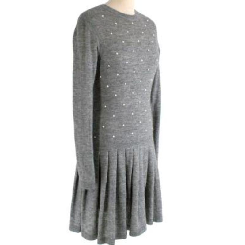 Chanel Faux Pearl Embellished Pleated Knit Dress
 
 - Long-sleeved grey cashmere blend midi dress with faux pearl embellishments 
 - Double C logo pin 
 - Pleated skirt 
 - Zip fastening at the back 
 - Includes slip dress with stitched detailing