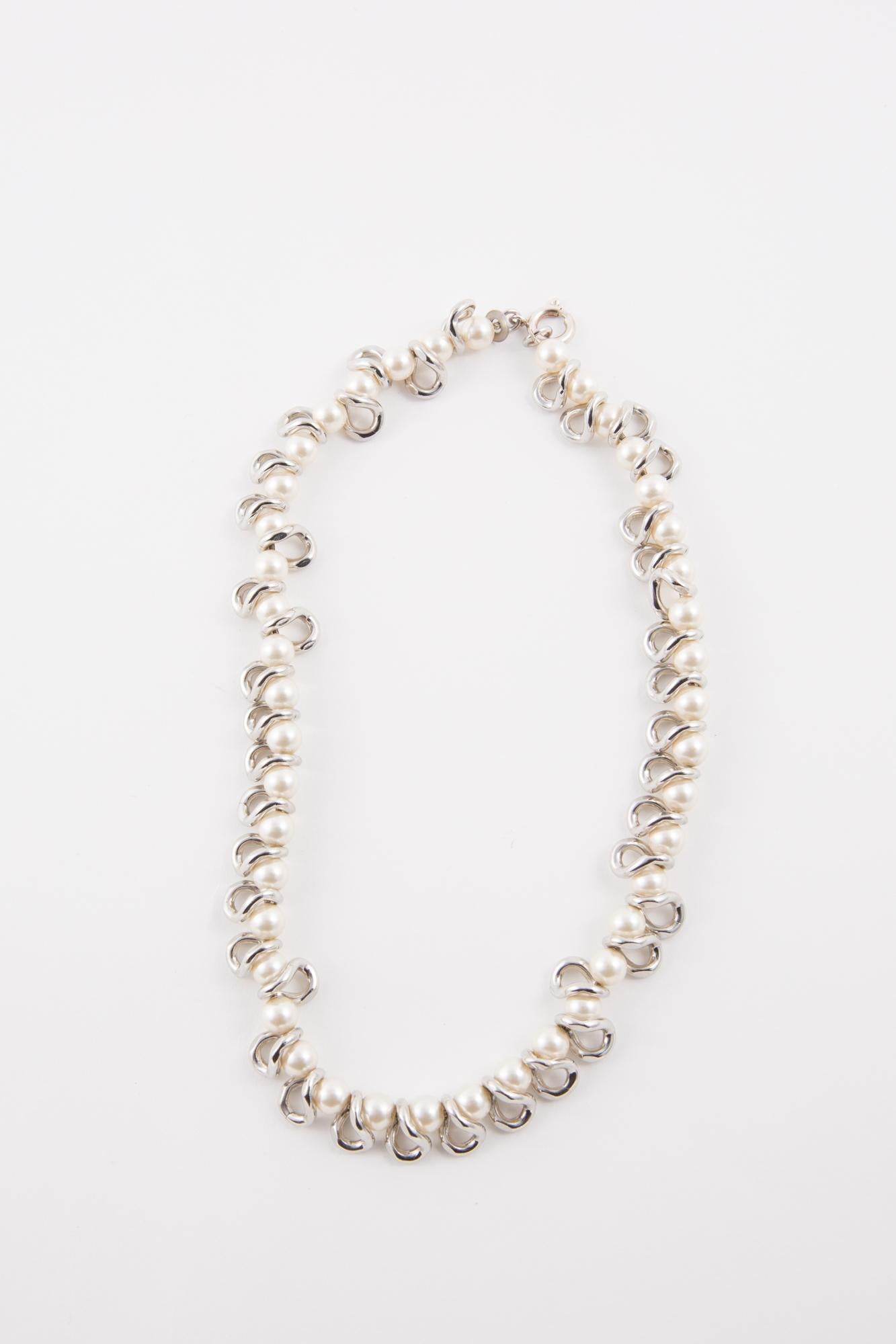Ligia Dias faux pearls and silver tone chain links necklace featuring silver tone free links, a pitted logo plaque, a claps opening. 
In excellent vintage condition  Made in France. 
Length: 17.3in. (44cm)
Width: 0.60in (1.5cm)
We guarantee you will
