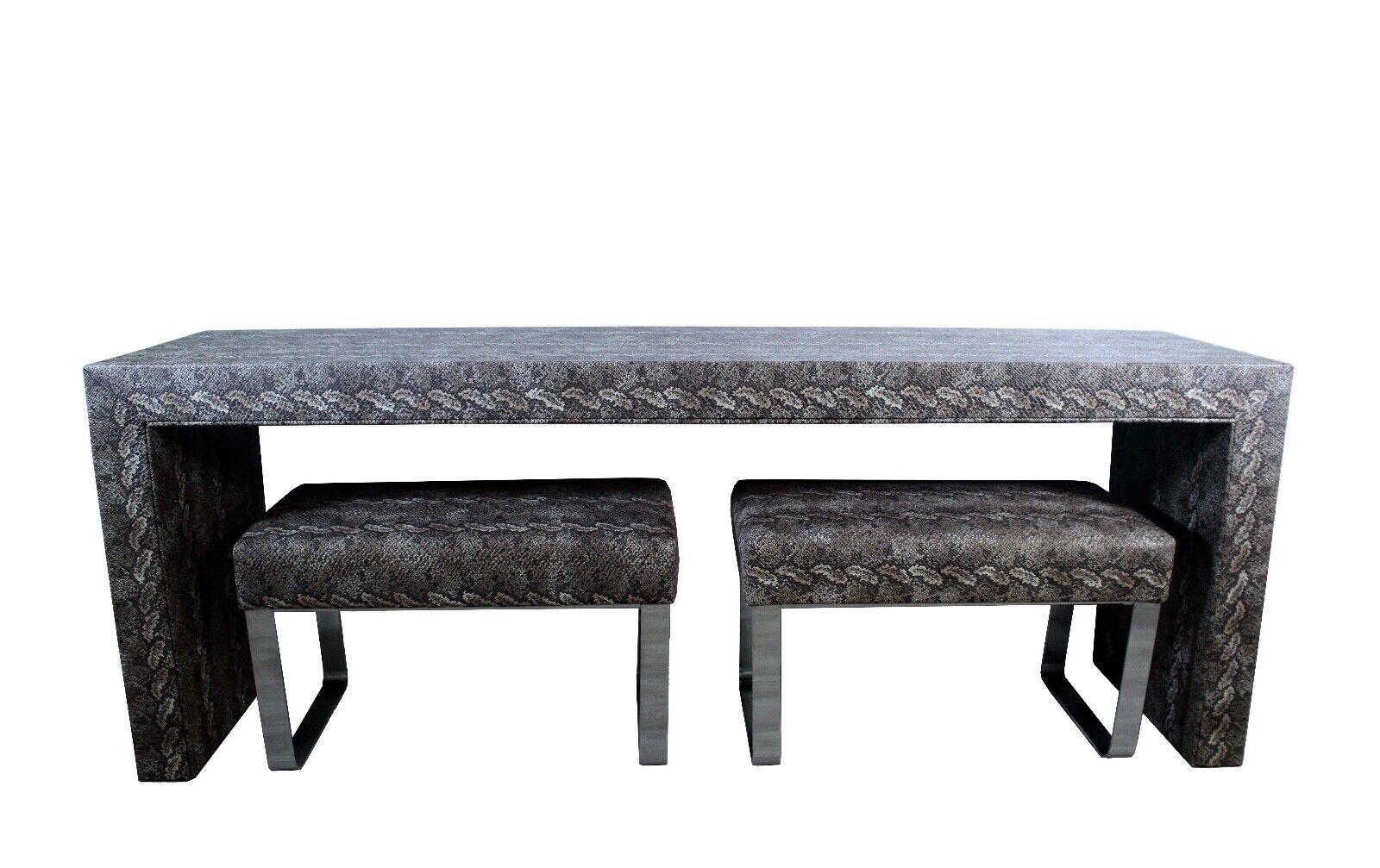 These stunning faux python covered ottomans are sure to be a conversation piece in any room. The ottomans are made of a durable chrome construction with a faux python patterned fabric covering. Perfect for a living room, entryway, or bedroom, this