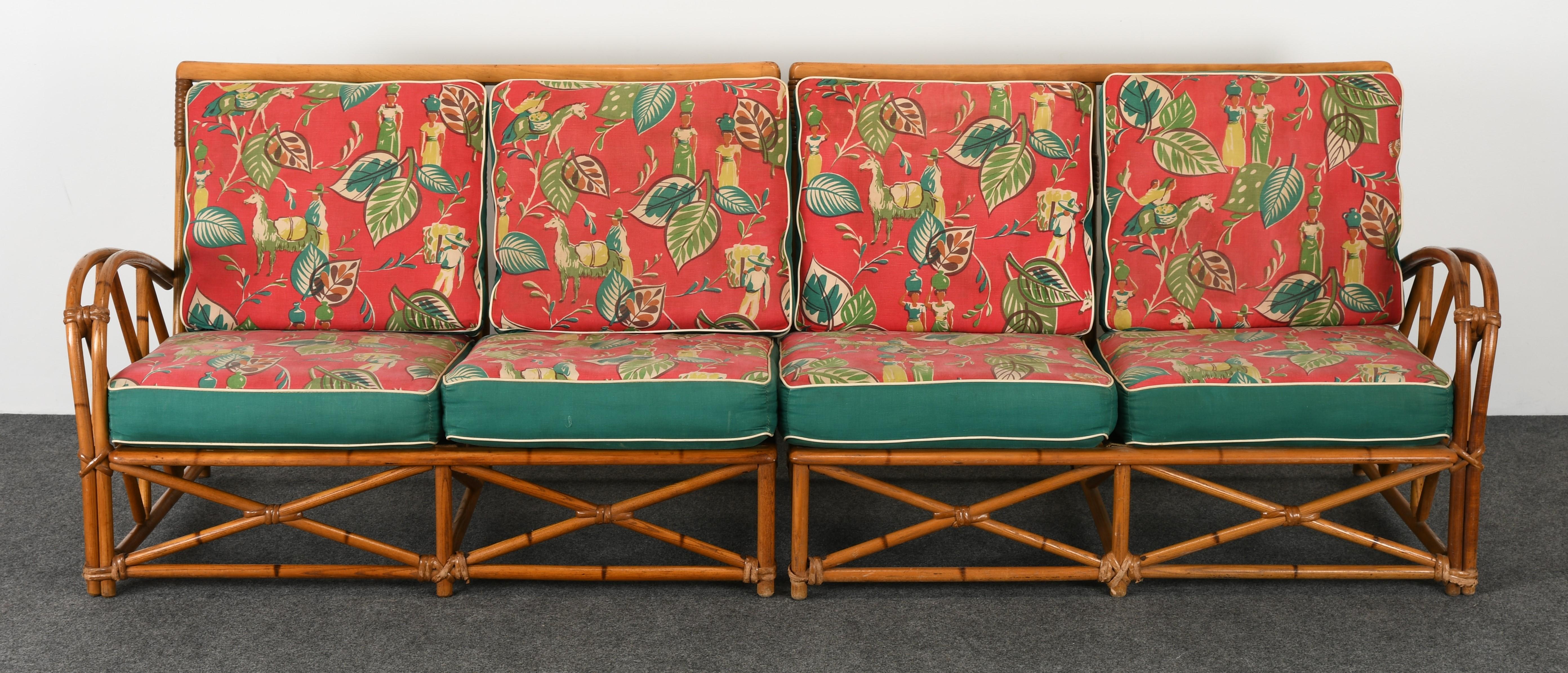 A handsome faux rattan sofa made of oak wood and upholstered cushions by Heywood Wakefield, circa 1950s. This beautiful sofa is structurally sound but has some loose rattan wrappings or windings. The sofa cushions have the original vintage fabric