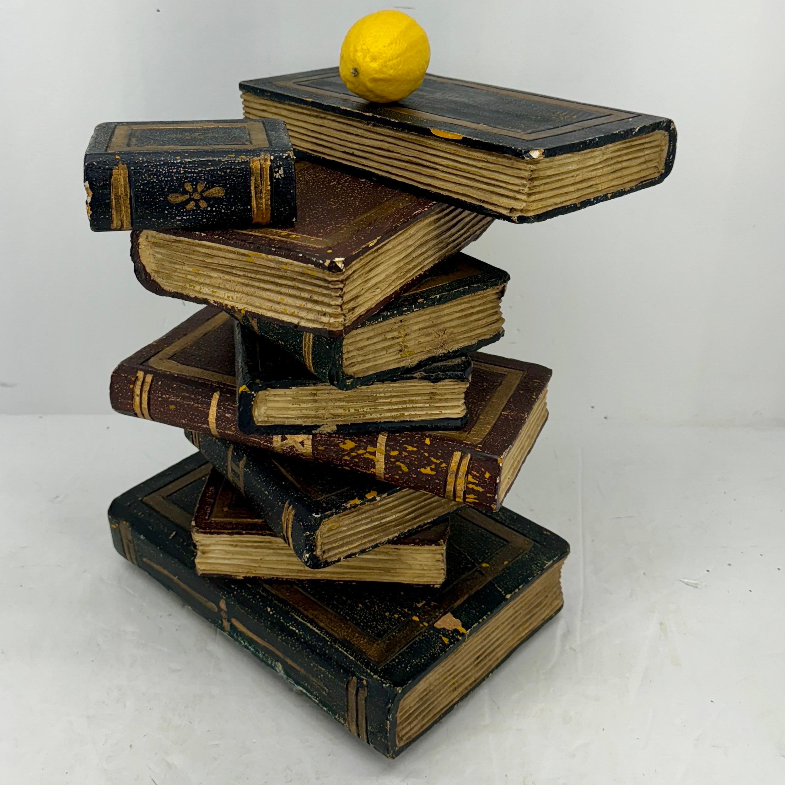 This charming side table featuring nine wood faux books in a realistic form with each book showing texture and great patina. Each book has been painted in warm tones with gold details. This table certainly makes a statement and would look fantastic