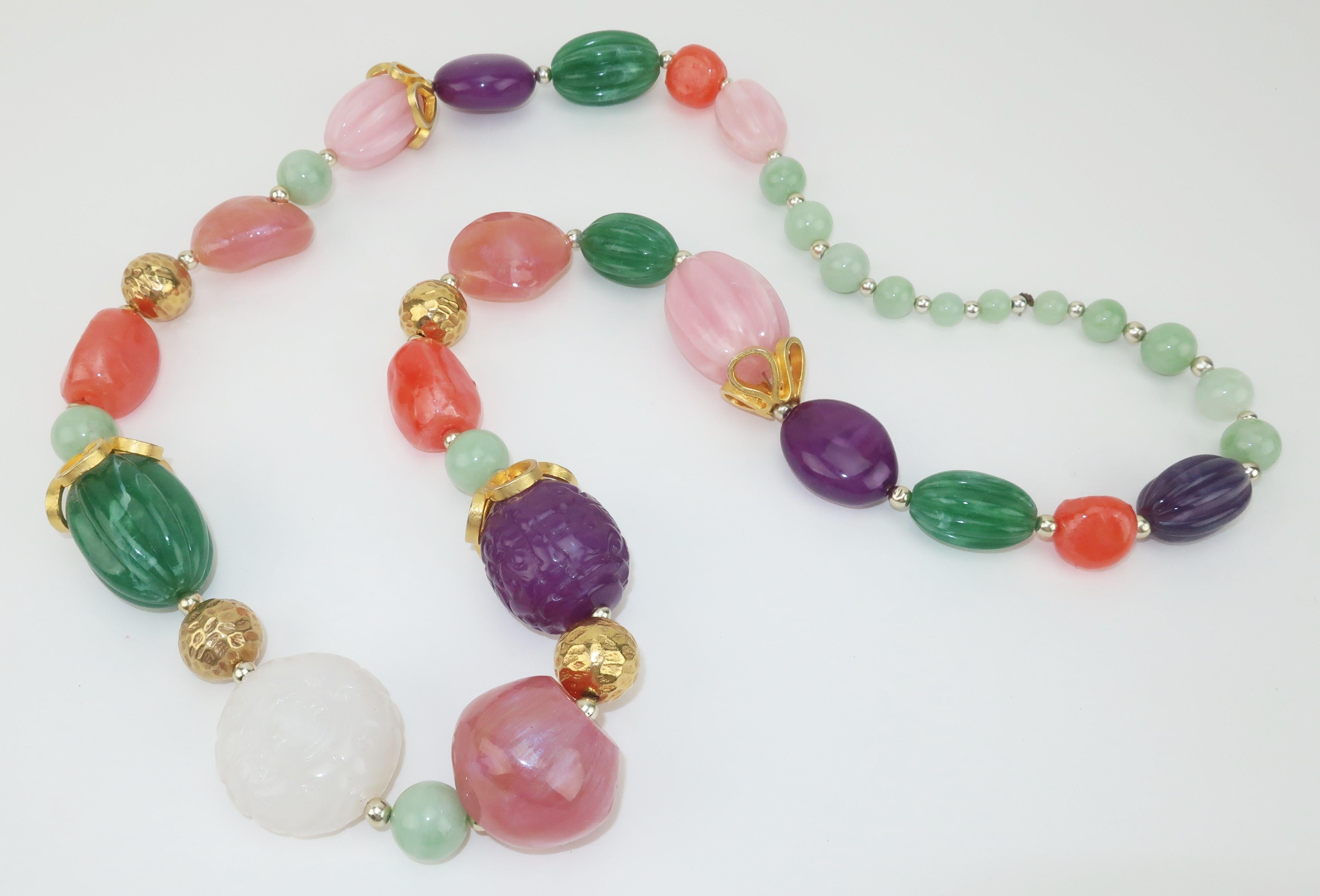 1980's chunky resin bead necklace with the appearance of semi-precious stones accented with gold tone metal fittings and dimpled beads.  Some of the 'stones' are carved with an Asian motif and the smaller beads at the back of the necklace have the
