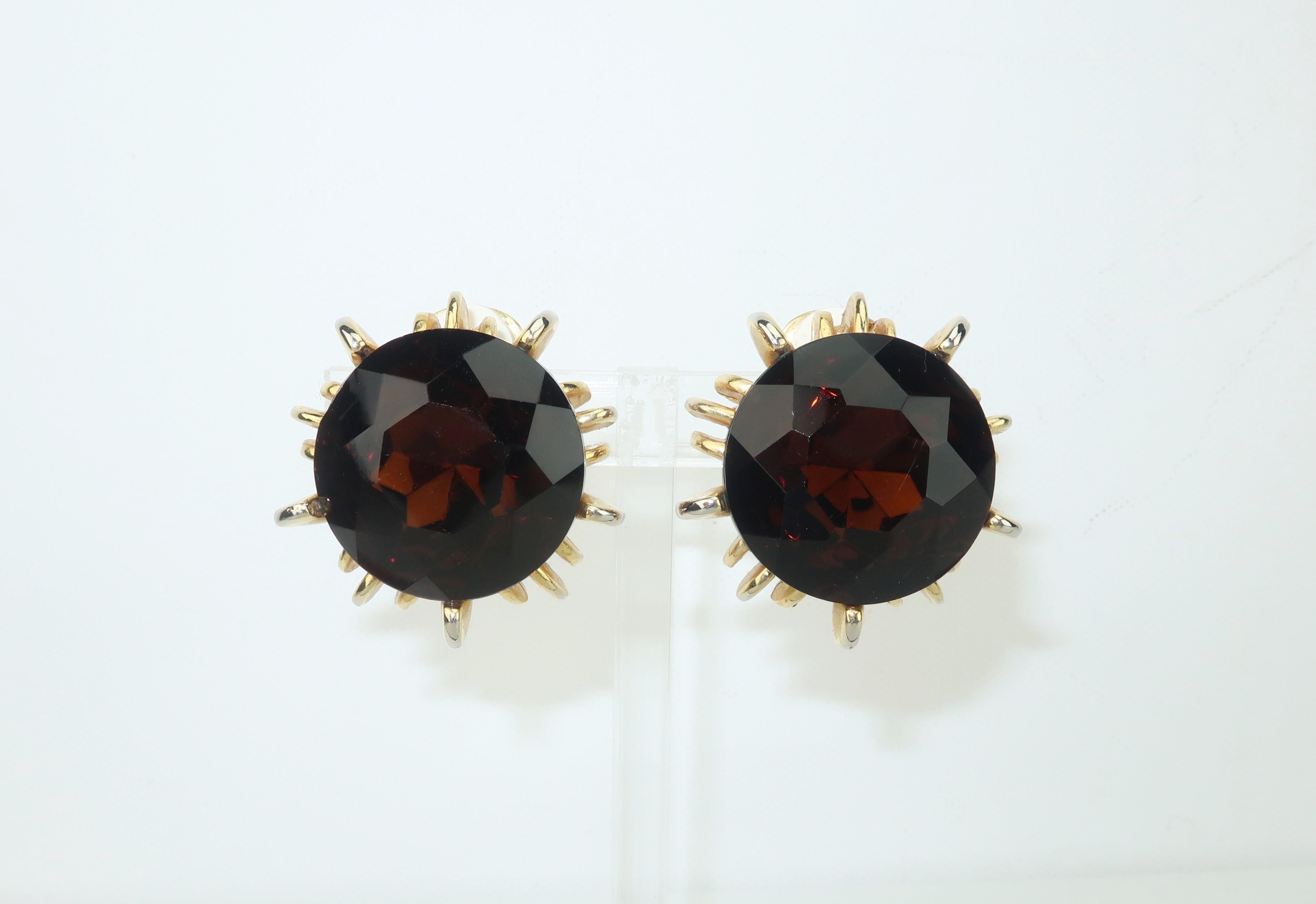 Faceted brown glass earrings with a smoky topaz look in a gold tone brutalist setting with clip on hardware.  No maker's mark though quality in style and appearance.
CONDITION
Good condition with a rough back edge to one stone as shown in photograph