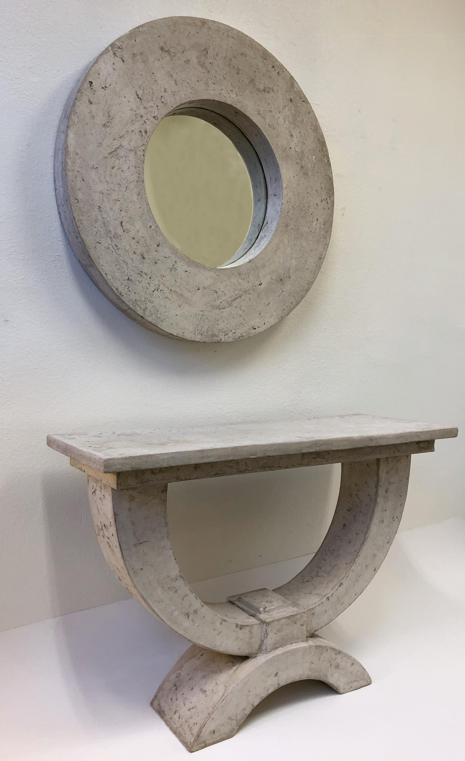 O spectacular faux stone console table and wall mirror design by Michael Taylor. The table and mirror are constructed of fiberglass made to look like stone. This can be used indoors or outdoors. 
Dim:
Mirror- 39.5” diameter 4.25” deep.
Table-