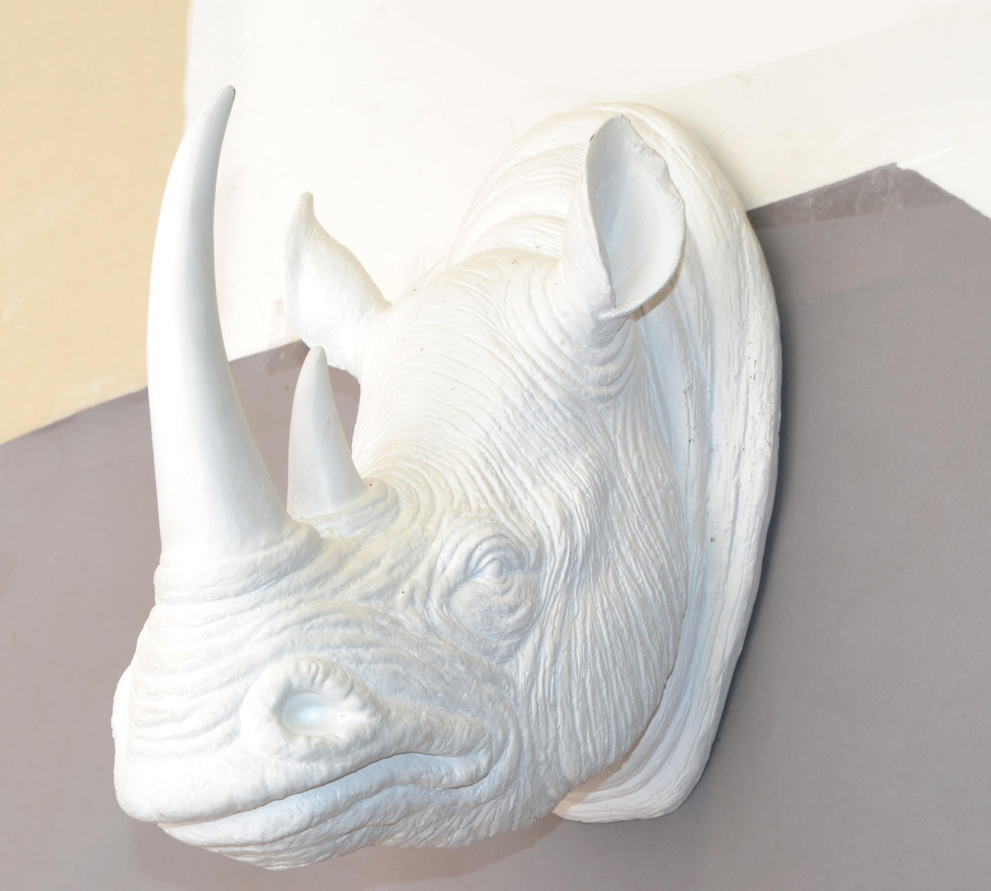 Ceci est une fausse tête de rhinocéros taxidermie, fausse tête de trophée, sculpture animale murale faite de résine et peinte dans une finition émaillée blanc cassé.
Notez les vraies rides de la peau et les détails des oreilles et du nez du