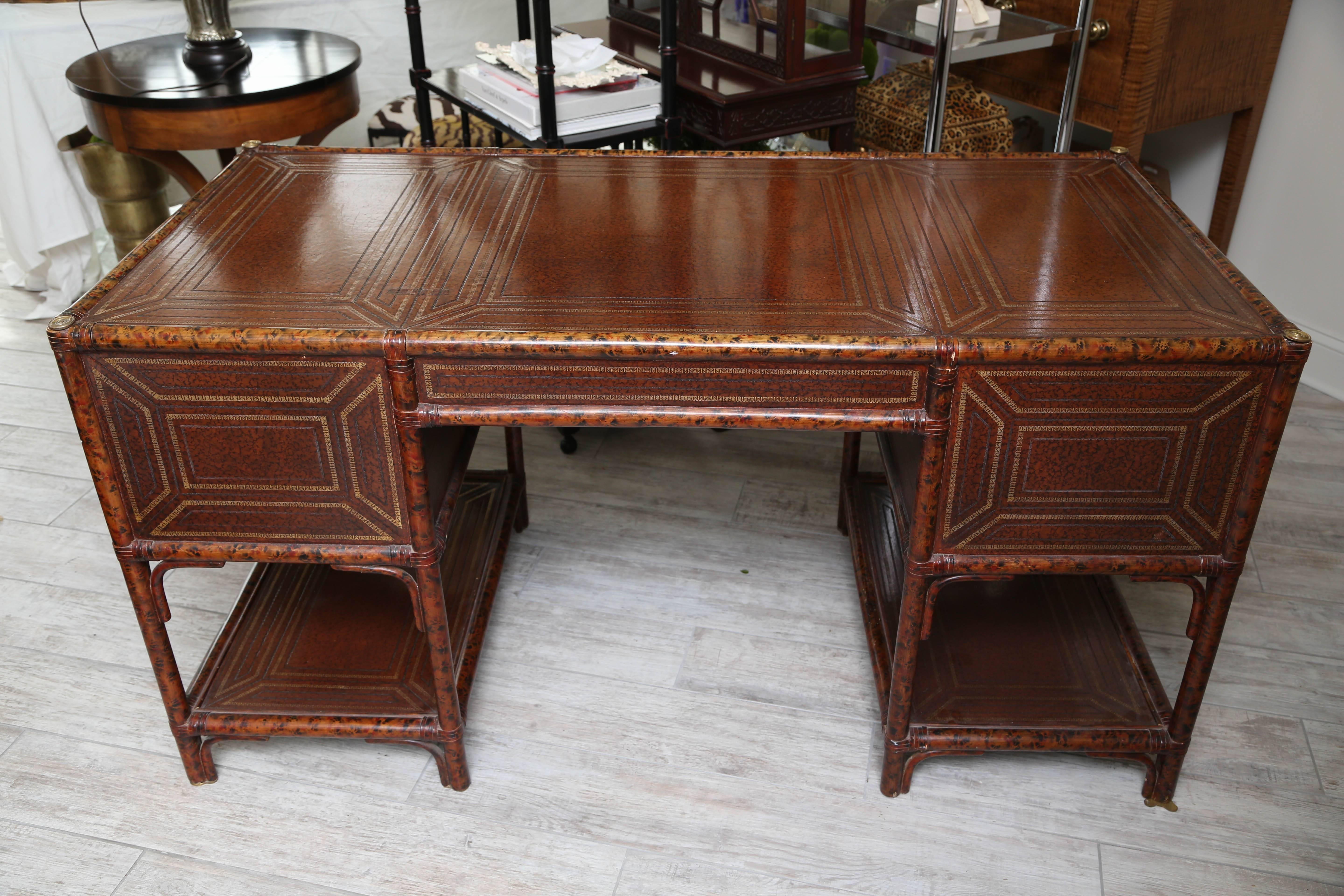 Faux bamboo tortoise style desk with embossed leather top, drawers and sides.