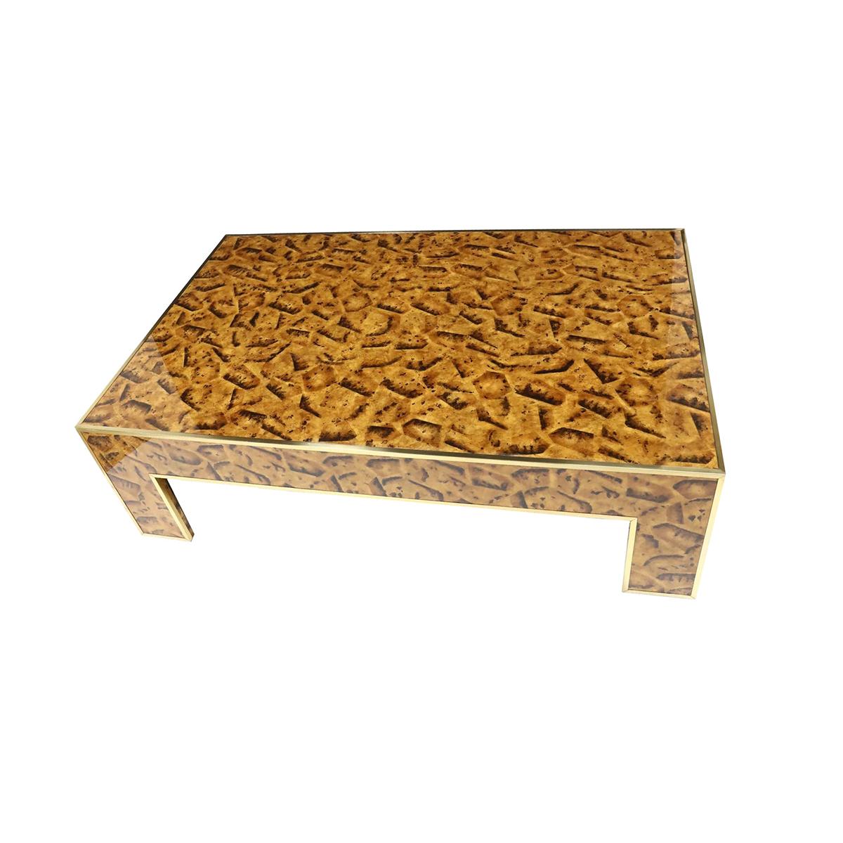 A modern style cocktail table with a hand-painted faux tortoise pen shell decoration. Framed with brass trim to all outside edges raised on short legs.

Dimensions: 54
