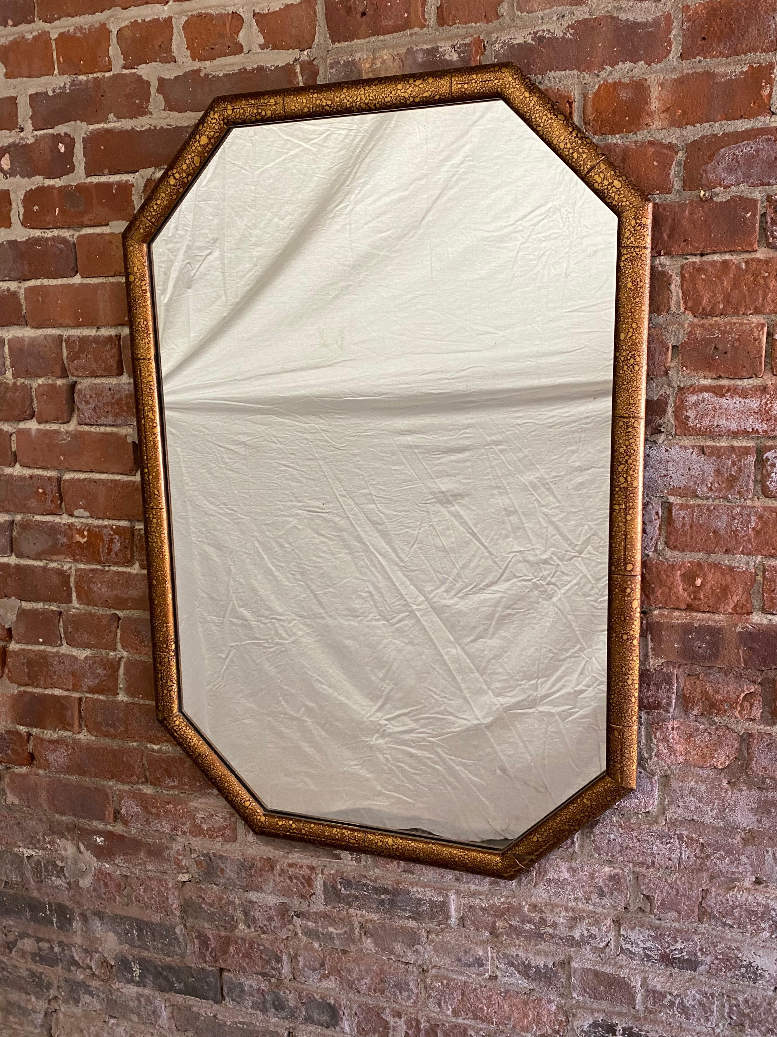 Wood framed octagonal tortoise shell finish mirror. Circa 1970. Dark brown with gold accents. Good overall condition with some minor scuffs, scratches and bruising to the wood surface. The mirror does not appear to have any silvering losses or