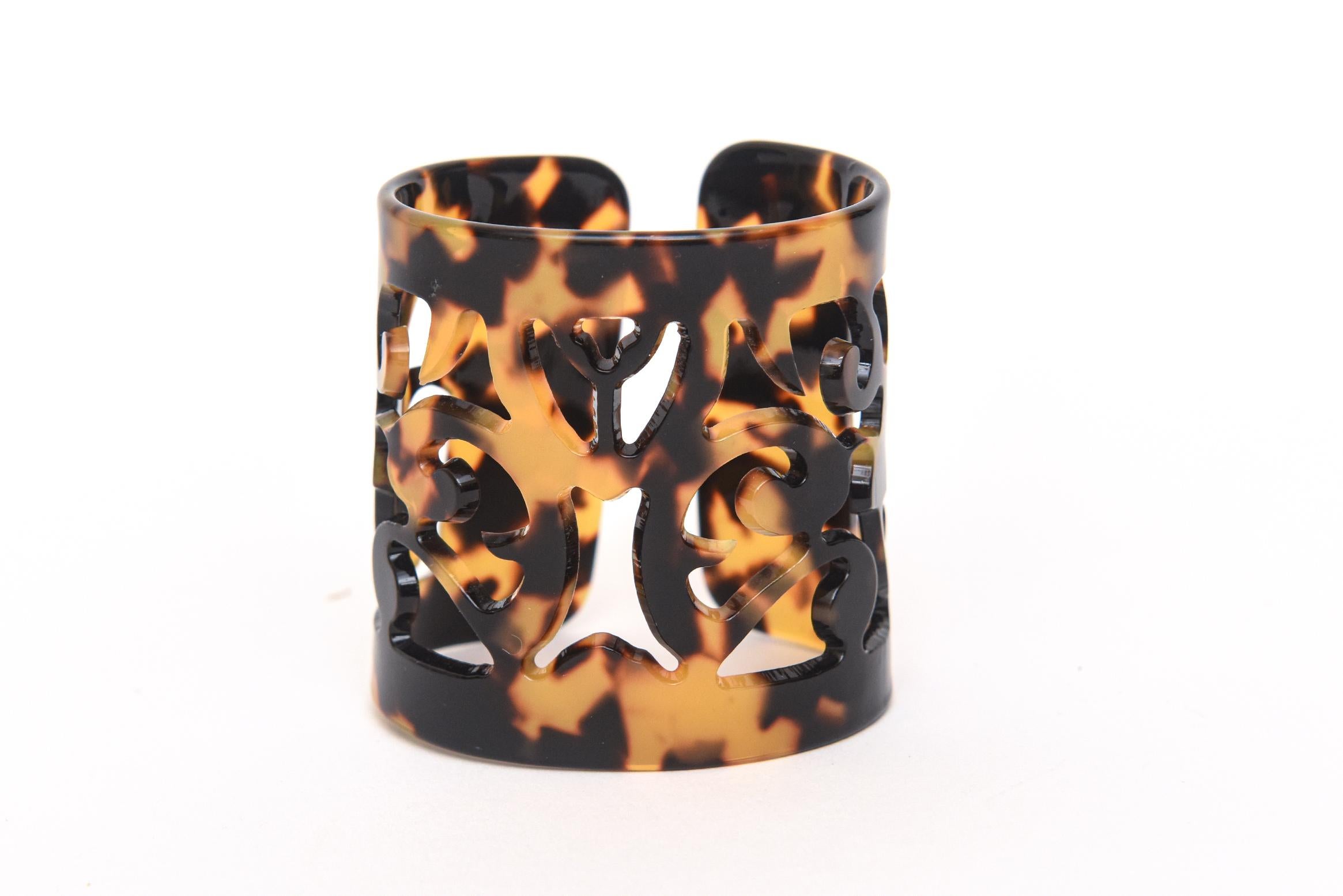 This wonderful wide cuff faux tortoise shell resin bracelet is so perfect to welcome in the seasons of 2023/ 2024.. This also looks great against white for more resort wear and warmer climates.The cut out fleur de lis designs give it an open look.