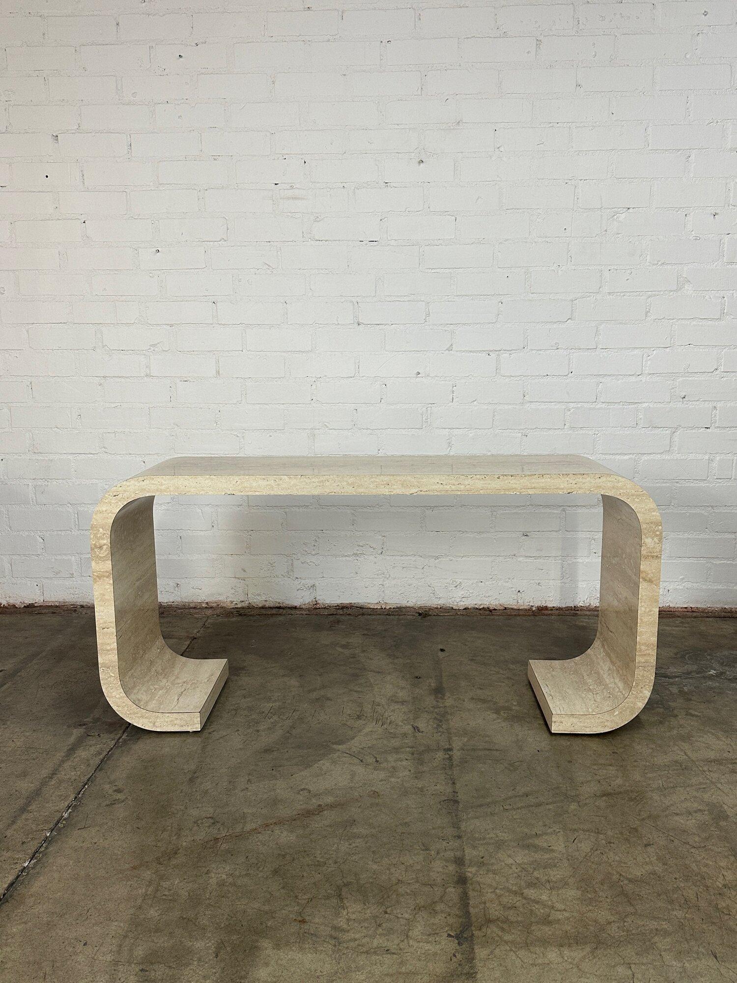 W60 D16 H29

Vintage post modern scroll console table. Item is well preserved with no major areas of wear. Console table or desk is structurally sound and sturdy. Item has travertine look and grain but it is thick laminate faux material. 