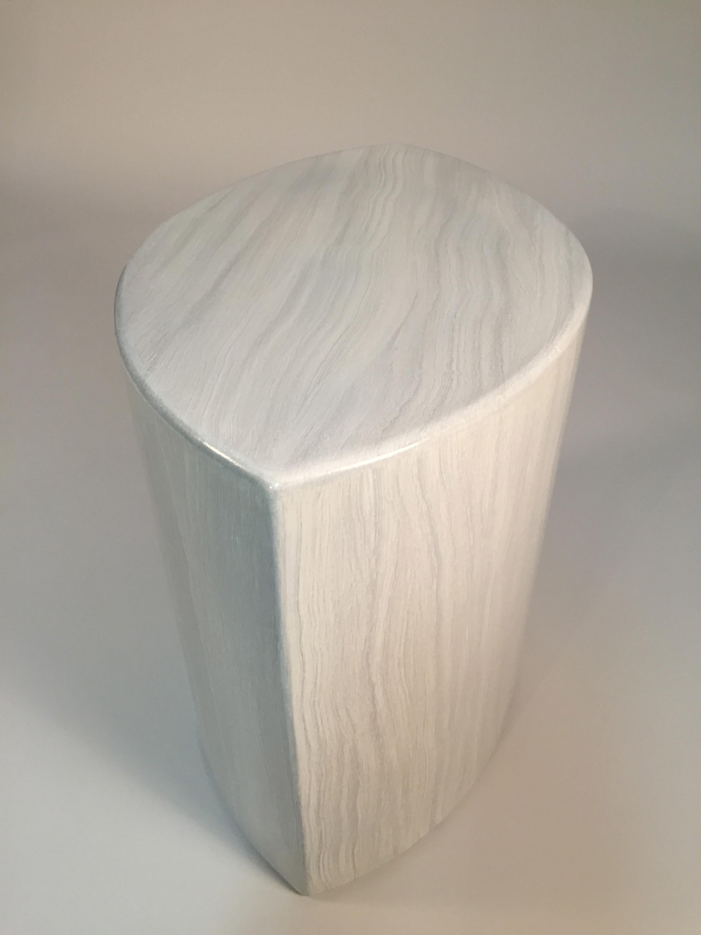 A lacquered hand shaped form has a brilliant gloss over a faux travertine. Faux stone allows the refined form an unorthodox grain curve and direction. Multi use for a side table or seating.