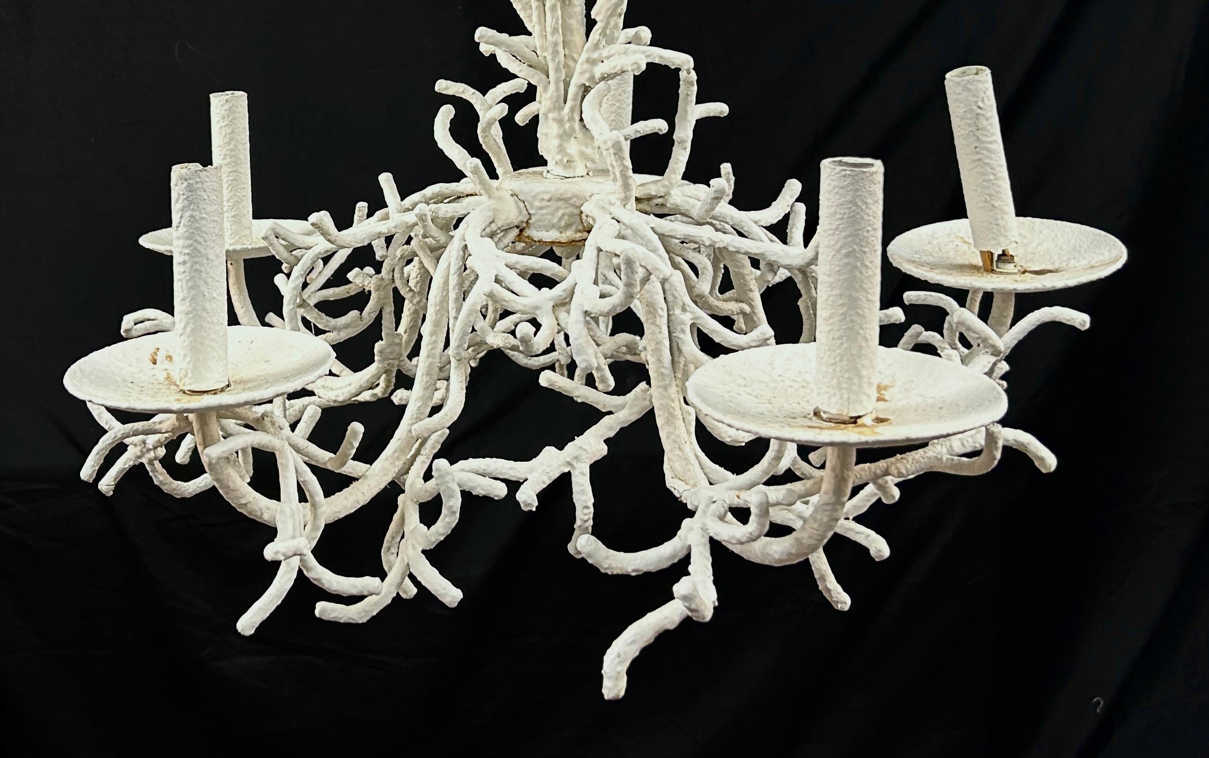 Mid-century faux iron coral chandelier combining the elegance of traditional chandeliers with the organic beauty of coral motifs. Features five lights and showcases intricate coral shapes and textures. Hand-painted in textured white finish. This