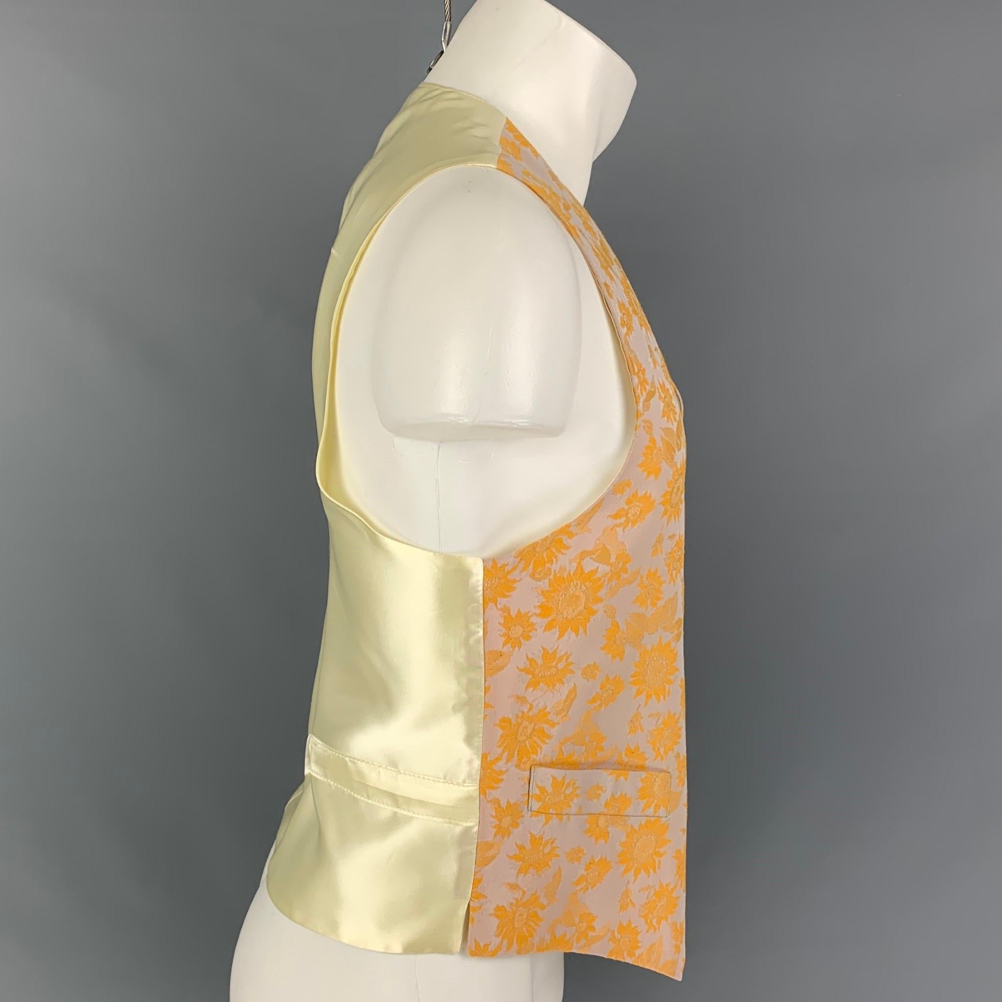 FAVOURBROOK vest comes in a orange & lavender floral print cotton featuring a back belt, front pockets, and a buttoned closure. Made in England. 

Very Good Pre-Owned Condition.
Marked: 42

Measurements:

Shoulder: 14.5 in.
Chest: 42 in.
Length: 22