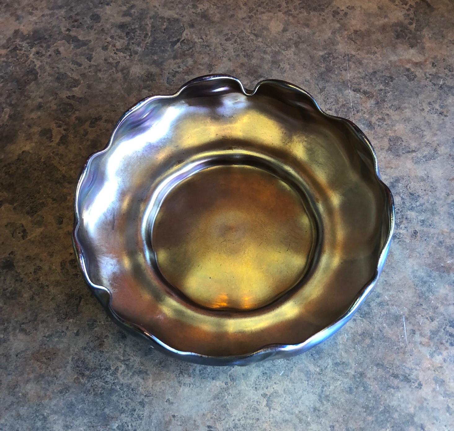 Gold iridescent favrile glass bowl from Tiffany & Co. with scalloped edges, circa early 20th century.

The bowl is 6