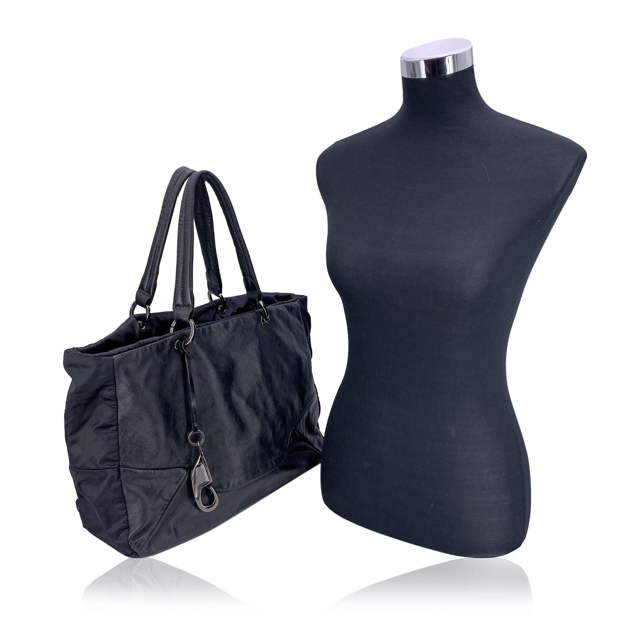 Introducing the Fay Black Soft Leather and Nylon Canvas Tote Shoulder Bag, a sophisticated yet practical accessory that embodies timeless style and quality craftsmanship. This stunning medium-sized tote is designed for both functionality and