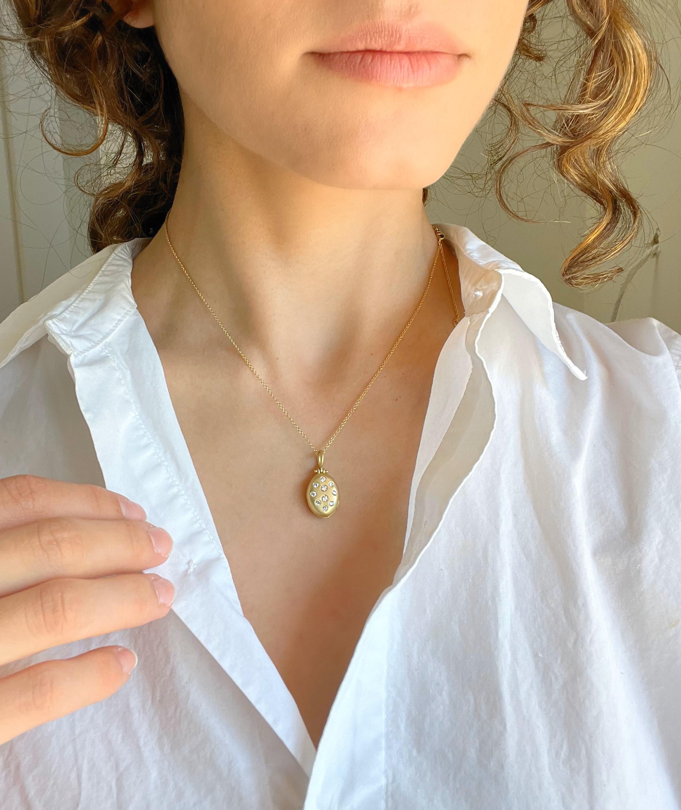 El Pequeño Relicario Ovalado de Oro de 18 Kilates y Diamantes de Faye Kim combina sustancia con estilo, y ofrece la cantidad justa de brillo. Este medallón, finamente elaborado a mano y con acabado mate, puede personalizarse con un grabado y