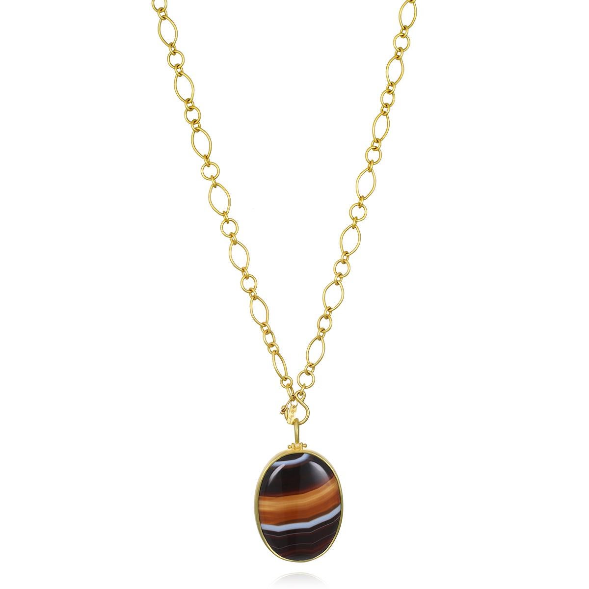 Faye Kim's 18 Karat Gold Banded Agate Hinged Pendant is bezel set and offers just the right amount of movement. 

This spectacular one-of-a-kind piece offers a lustrous display of multi-color banding and makes a striking design statement. 

Pendant