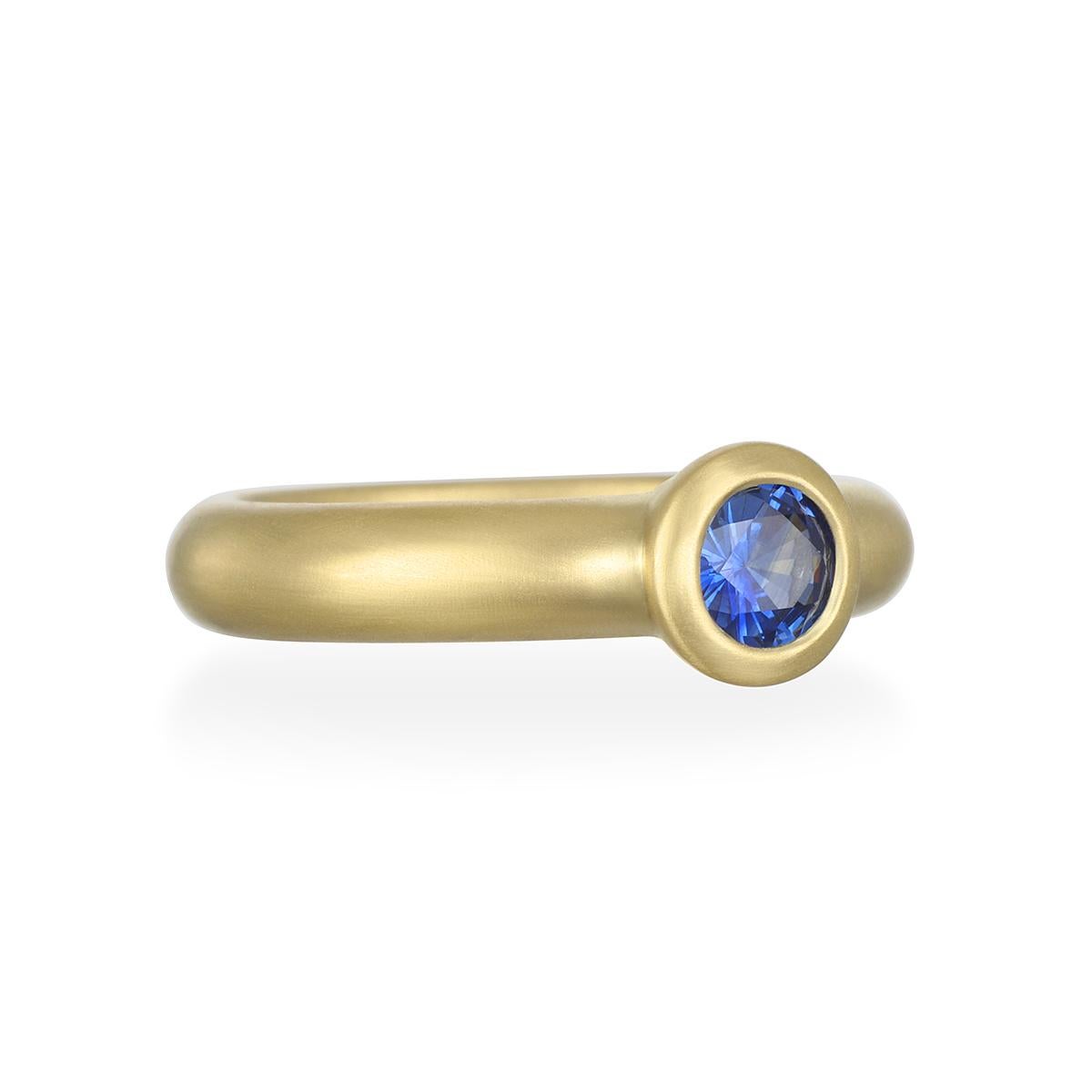 A beautiful, vivid shade of blue, this Ceylon Blue Sapphire round bezel ring is bezel set in 18K gold* with a matte finish for a clean, timeless look. It can be worn alone as a statement piece or stacked with other rings. Model pictured wearing a