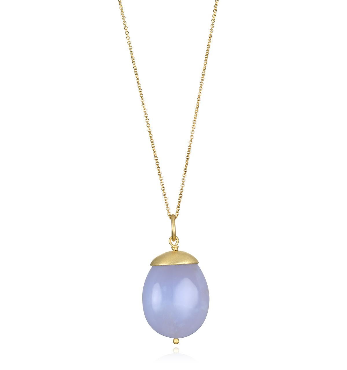 Faye Kim's 18 Karat Gold Chalcedony Nugget Pendant, with its translucent grayish-blue hue, is sure to make a design statement! This unique, one of a kind piece is finished with Faye's signature gold cap and bead.

Photos also show pendant on 18