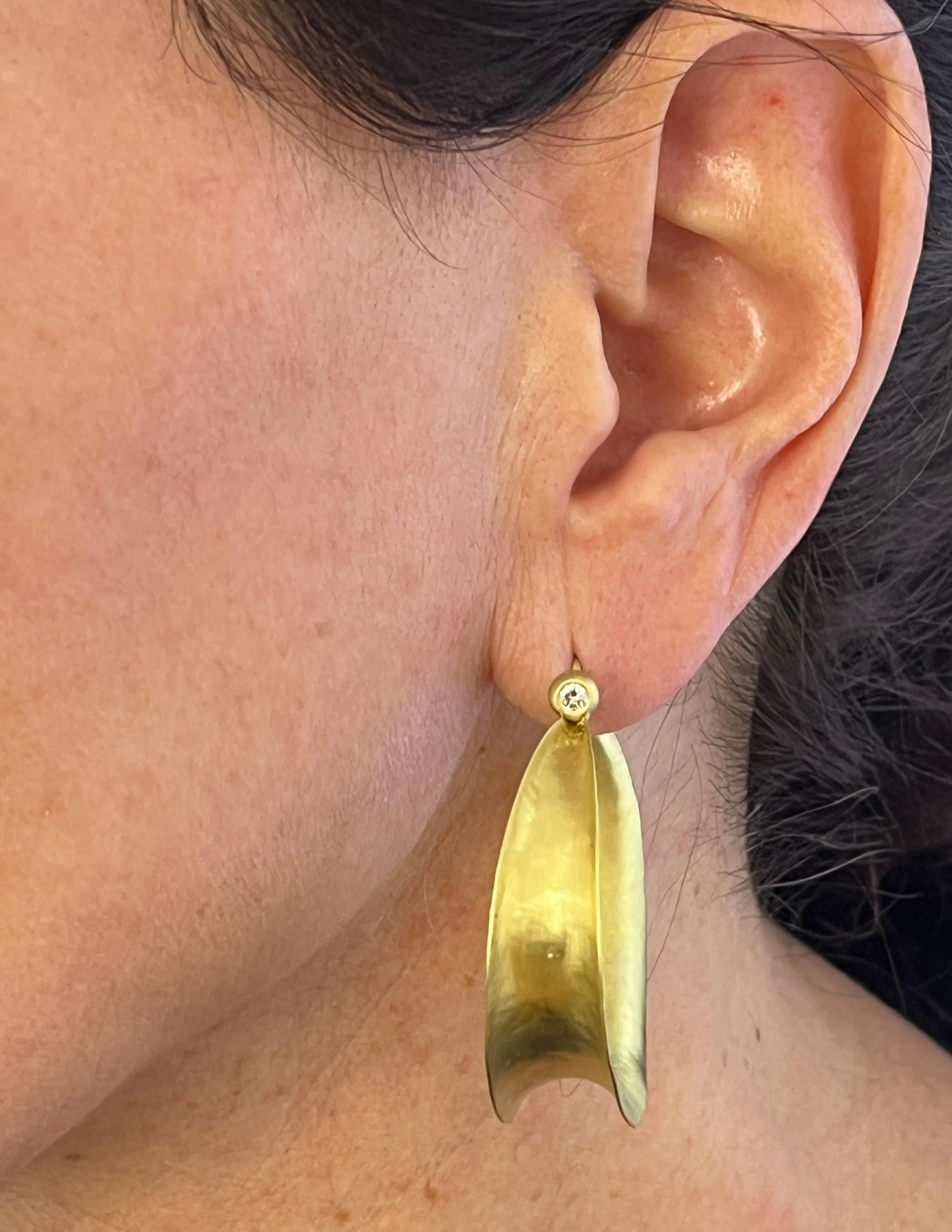 Faye Kim's 18 Karat Gold Diamond Anticlastic Hoop Earrings allow for strength and durability without added weight. The modern yet classic style features hoops finished with a bezel set diamond, adding the perfect amount of sparkle. 

Hoop length